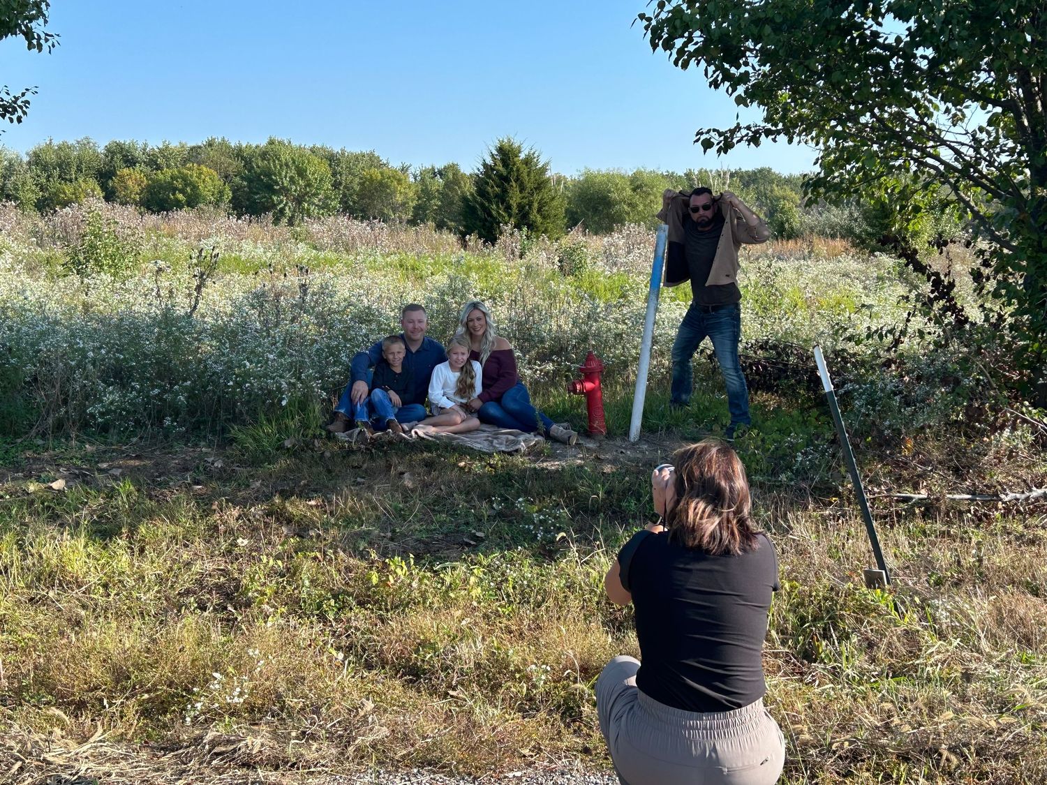 A series of scenic outdoor photos showing people sitting and relaxing in a grassy meadow area on a sunny day.