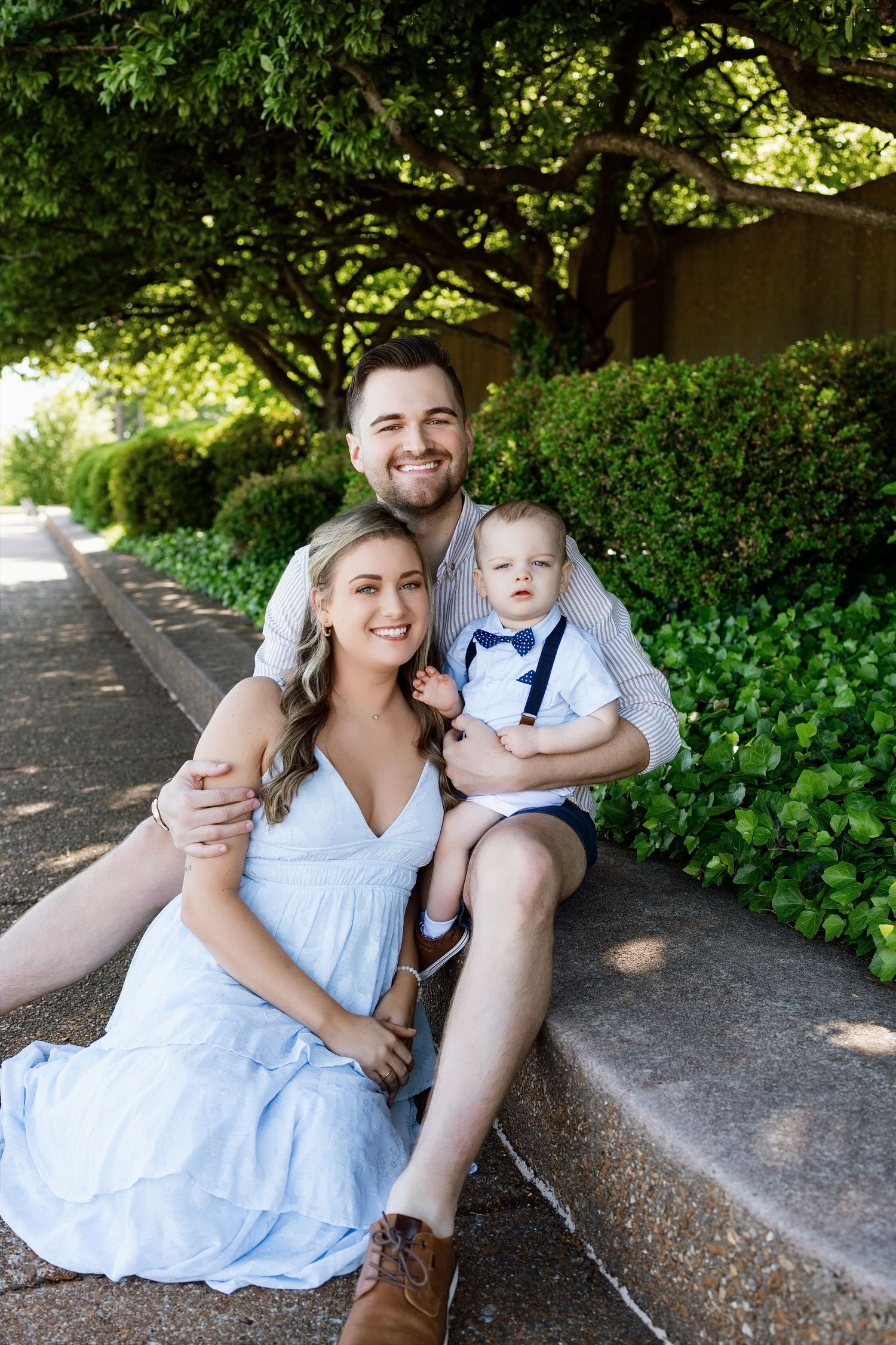 Family of three with a baby boy posing on outdoor steps during an Edwardsville family photography session