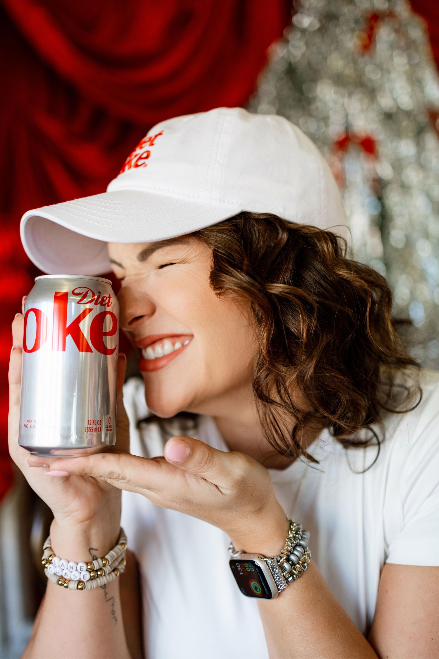 Playful photo series drinking from Diet Coke can with silver sequin backdrop and red curtains.