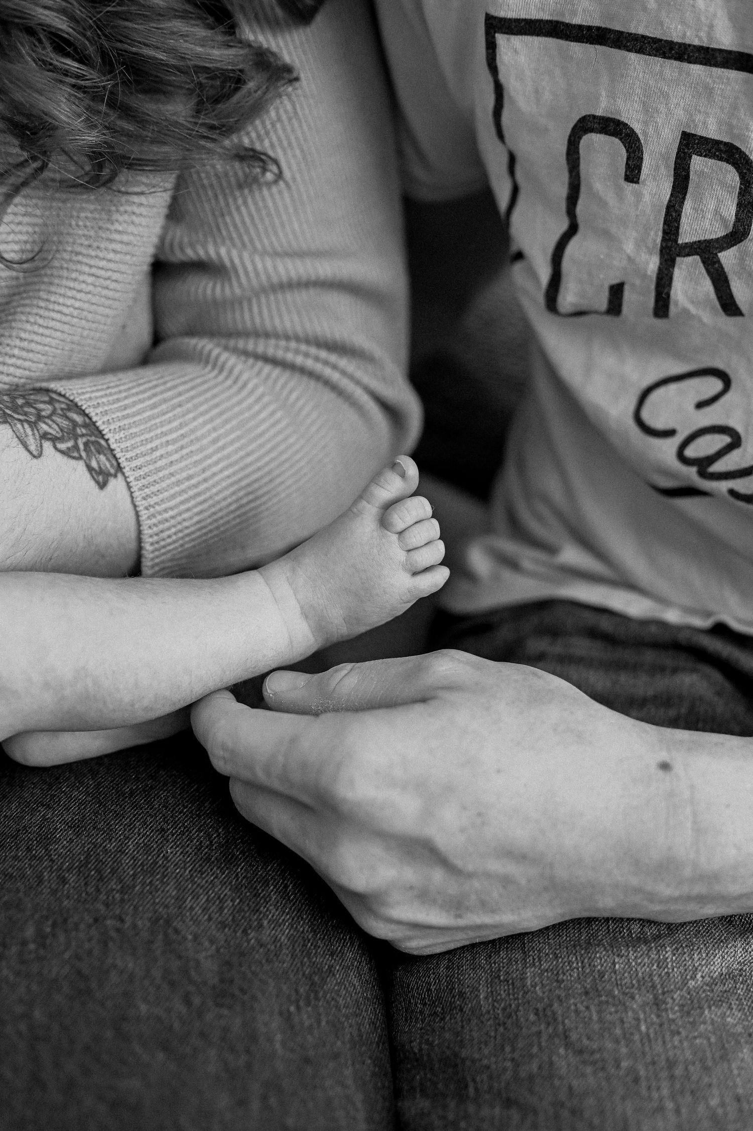 Parents cuddling newborn baby during in-home lifestyle newborn session.