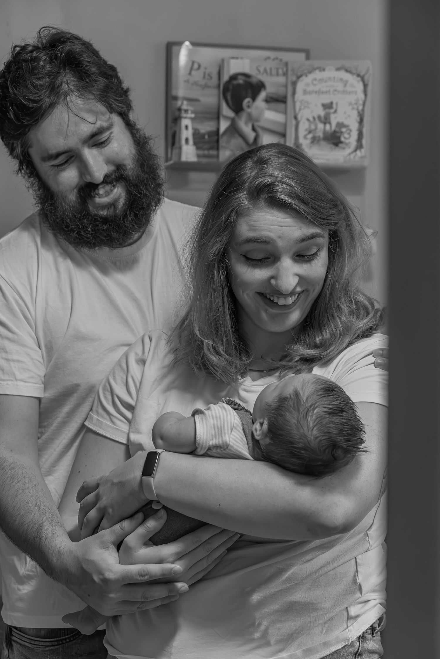 Parents cuddling newborn baby during in-home lifestyle newborn session in Prince Edward Island.