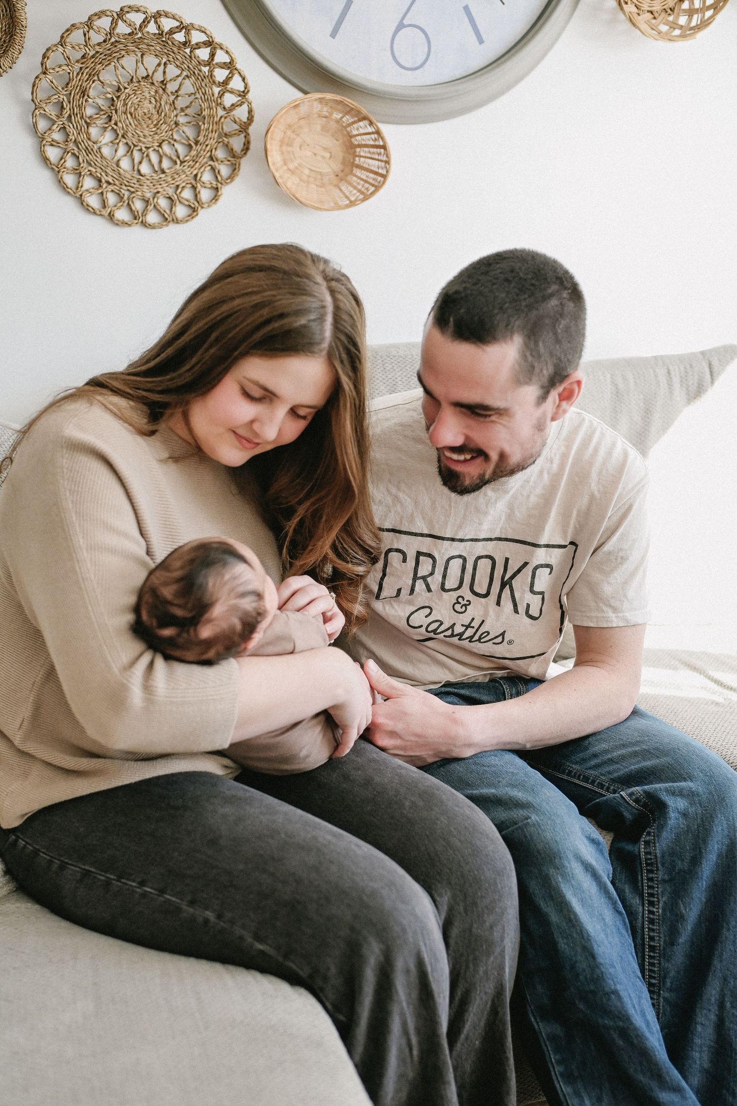 Baby with parents during newborn photo session.