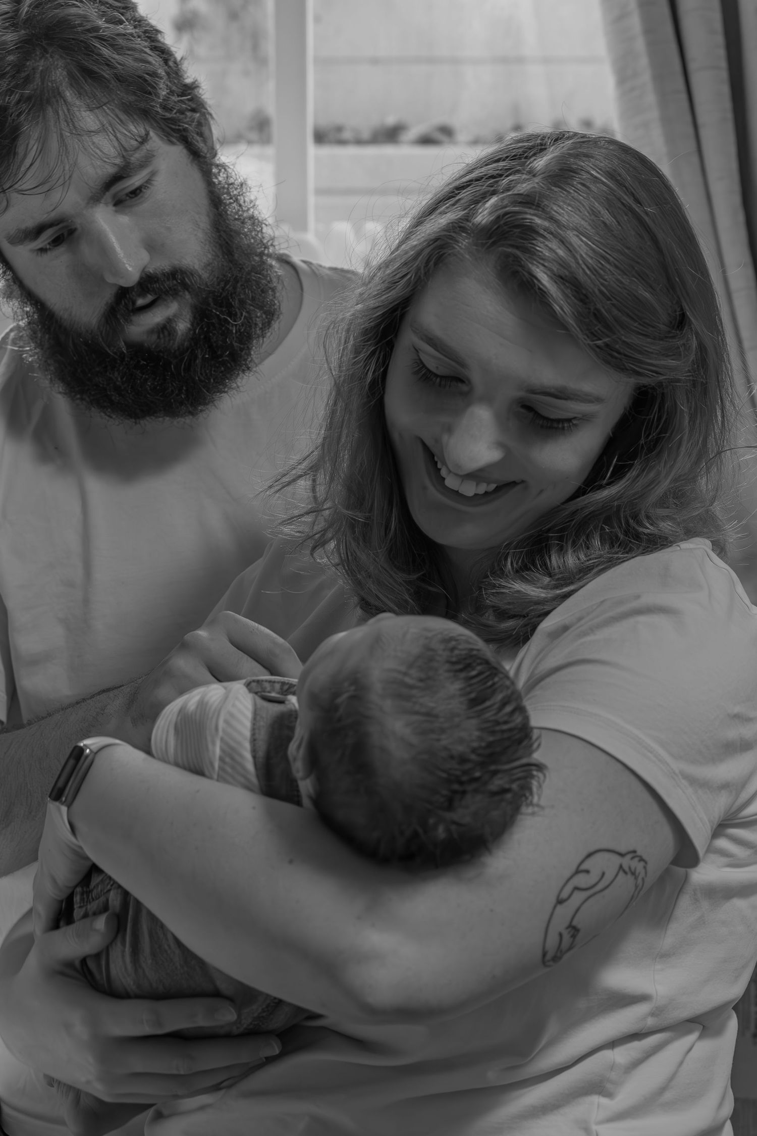 In-home newborn photography session in Prince Edward Island with parents holding their newborn baby