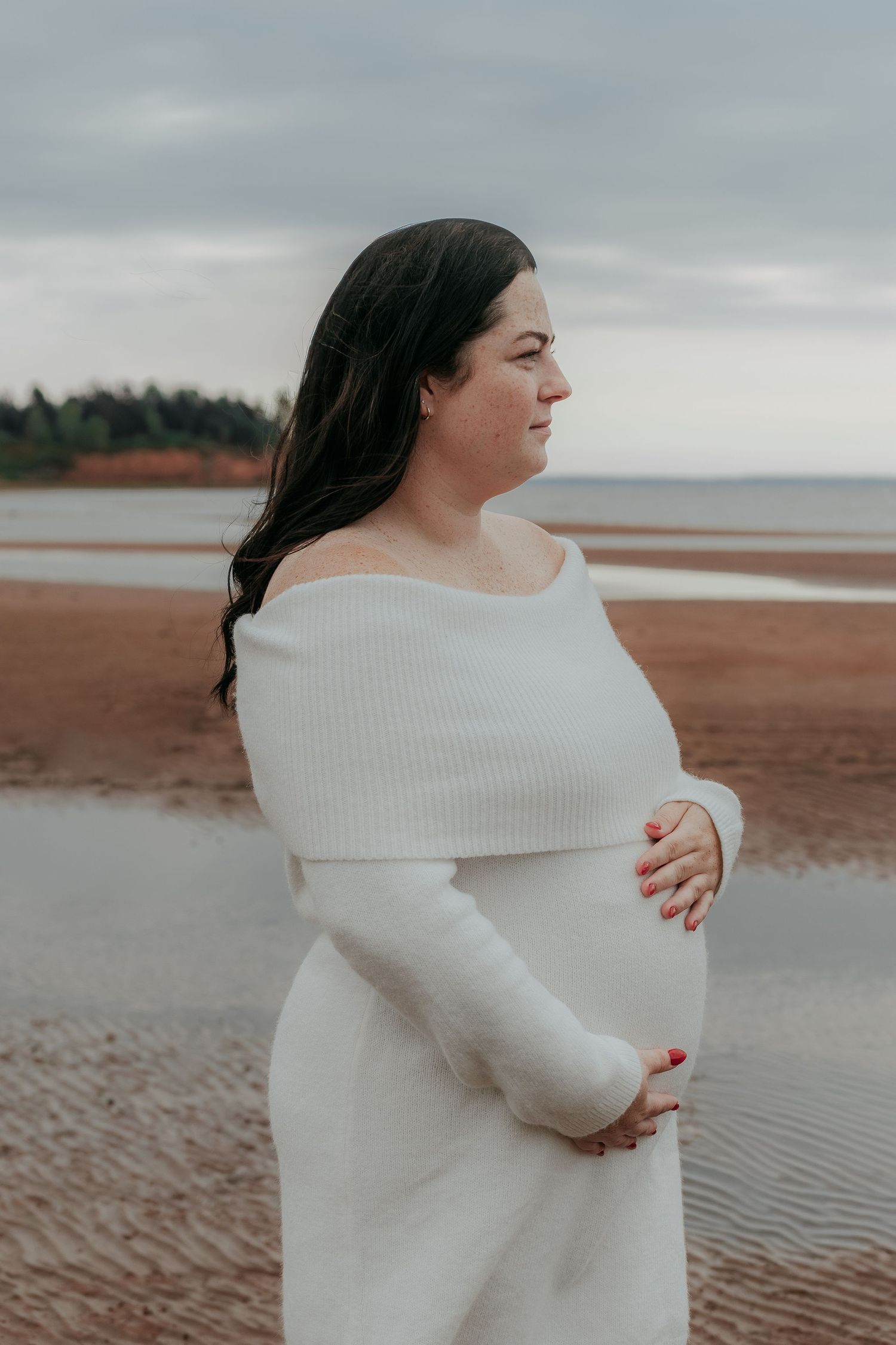 Candid maternity photography on red sand PEI beach