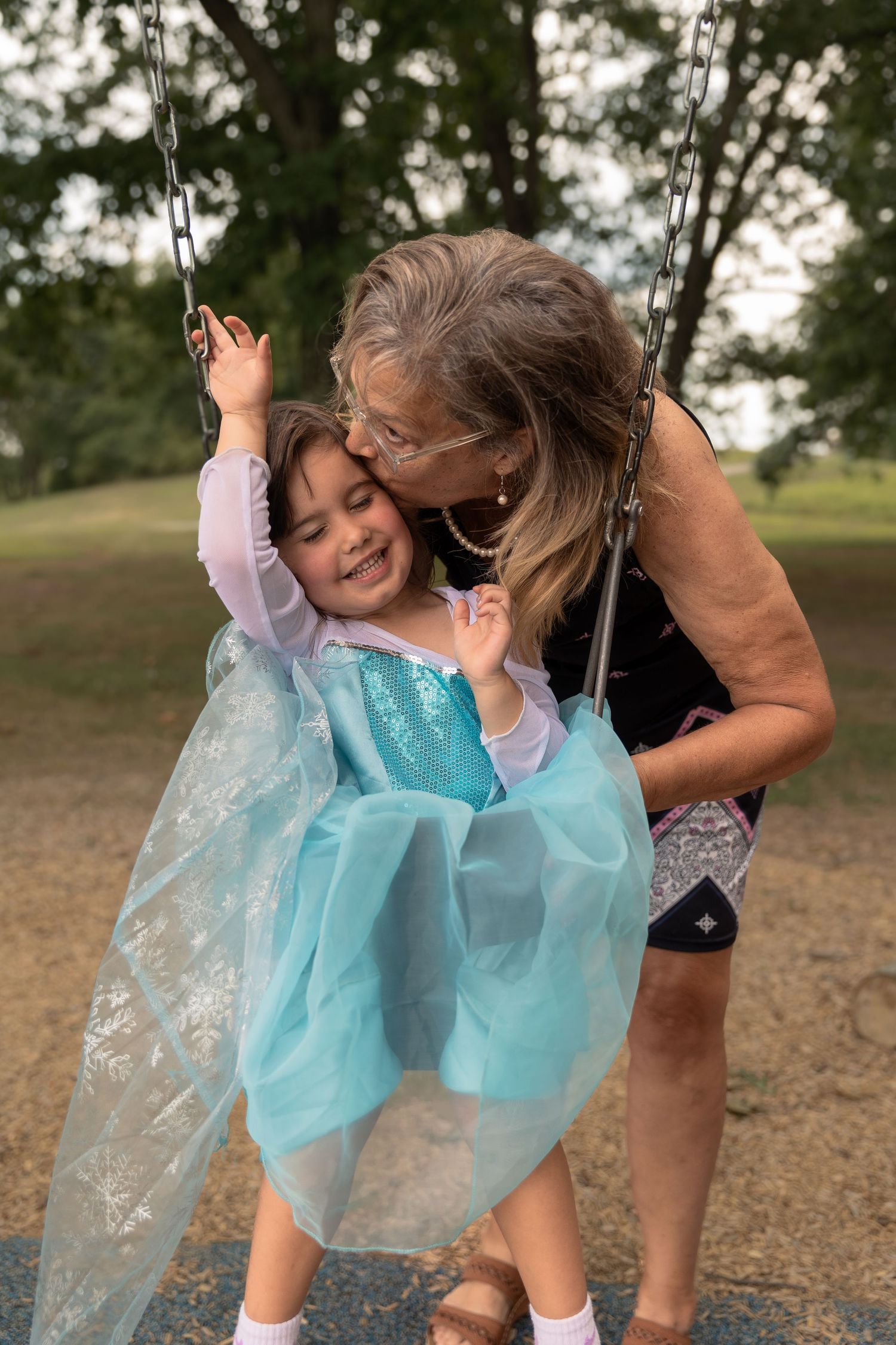 A sweet moment shared on a playground swing set during a magical outdoor celebration.