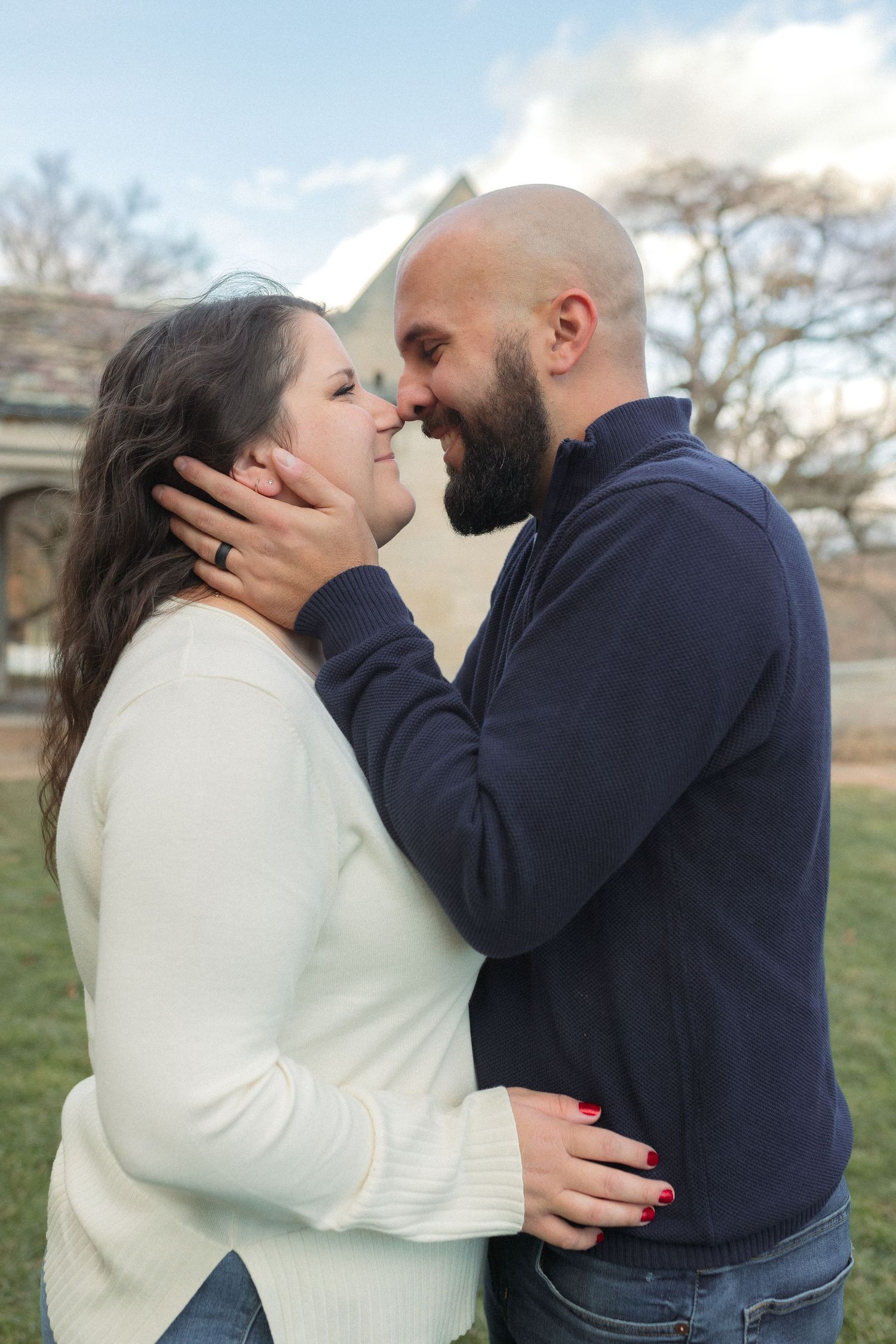 An intimate moment shared between a couple against the backdrop of a stone building.