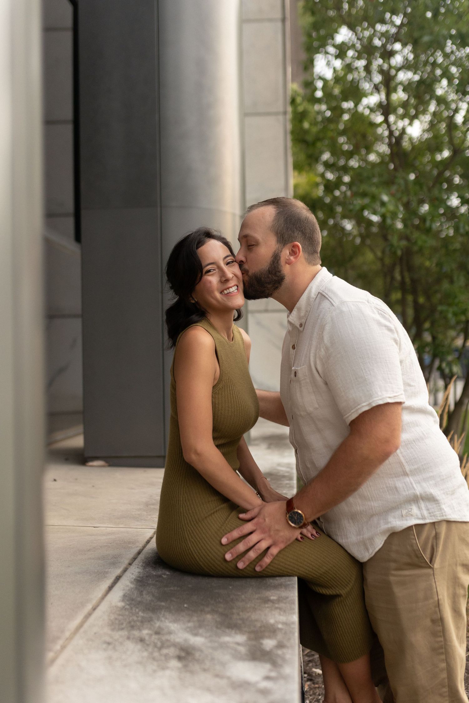 A tender moment shared between a couple beside architectural columns.
