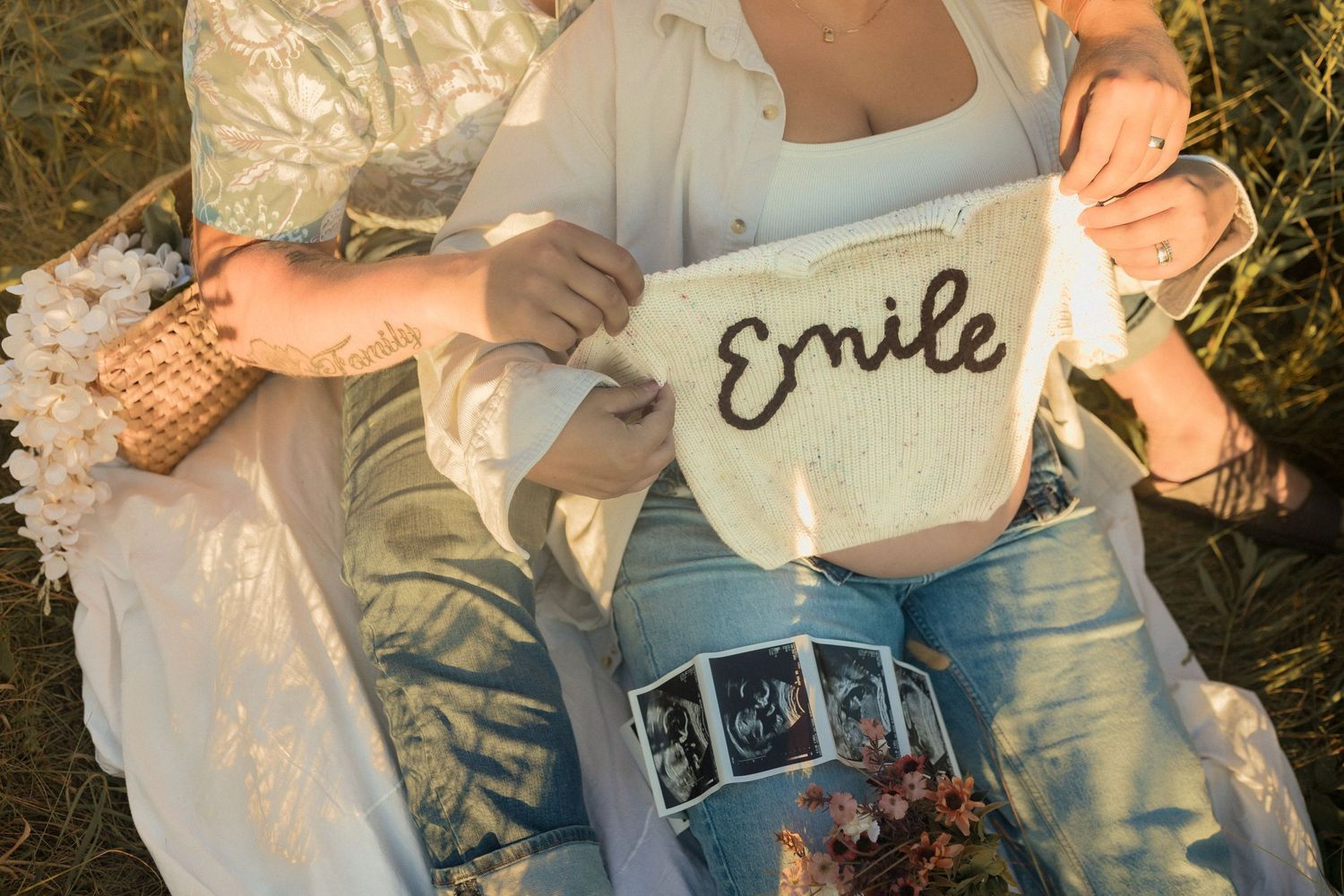 Pregnancy announcement with ultrasound photos and sign that says 'Smile' on blanket.