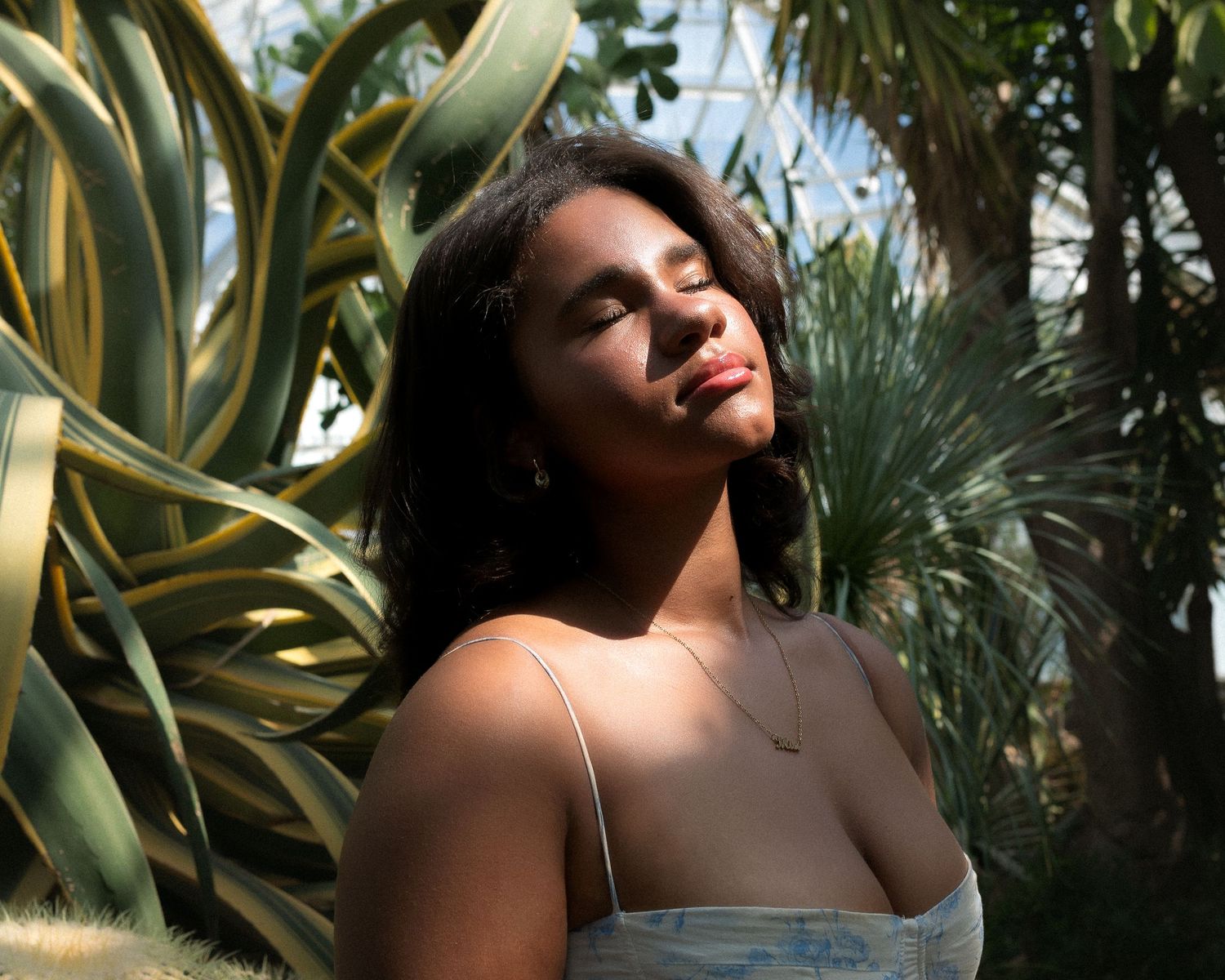 Artistic photo series showing someone posing against lush tropical foliage in natural sunlight.