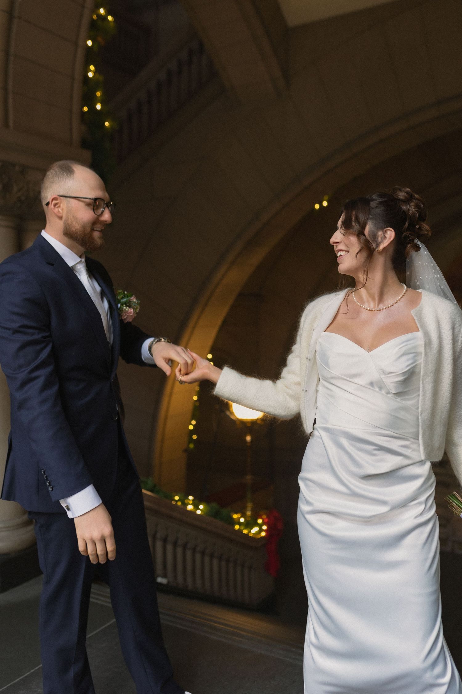 Joyful couple laughing together under arched doorway.