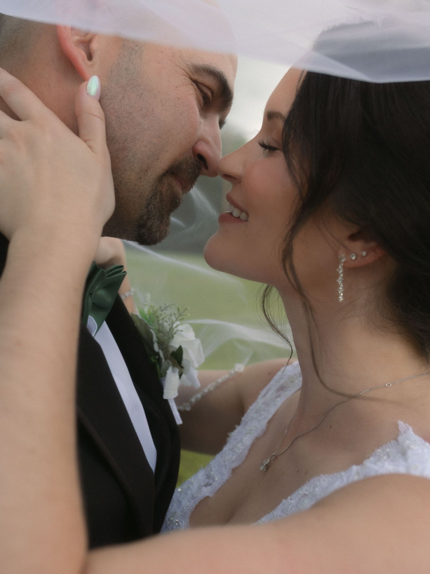 A romantic close-up of newlyweds sharing tender moments during an outdoor wedding photoshoot.