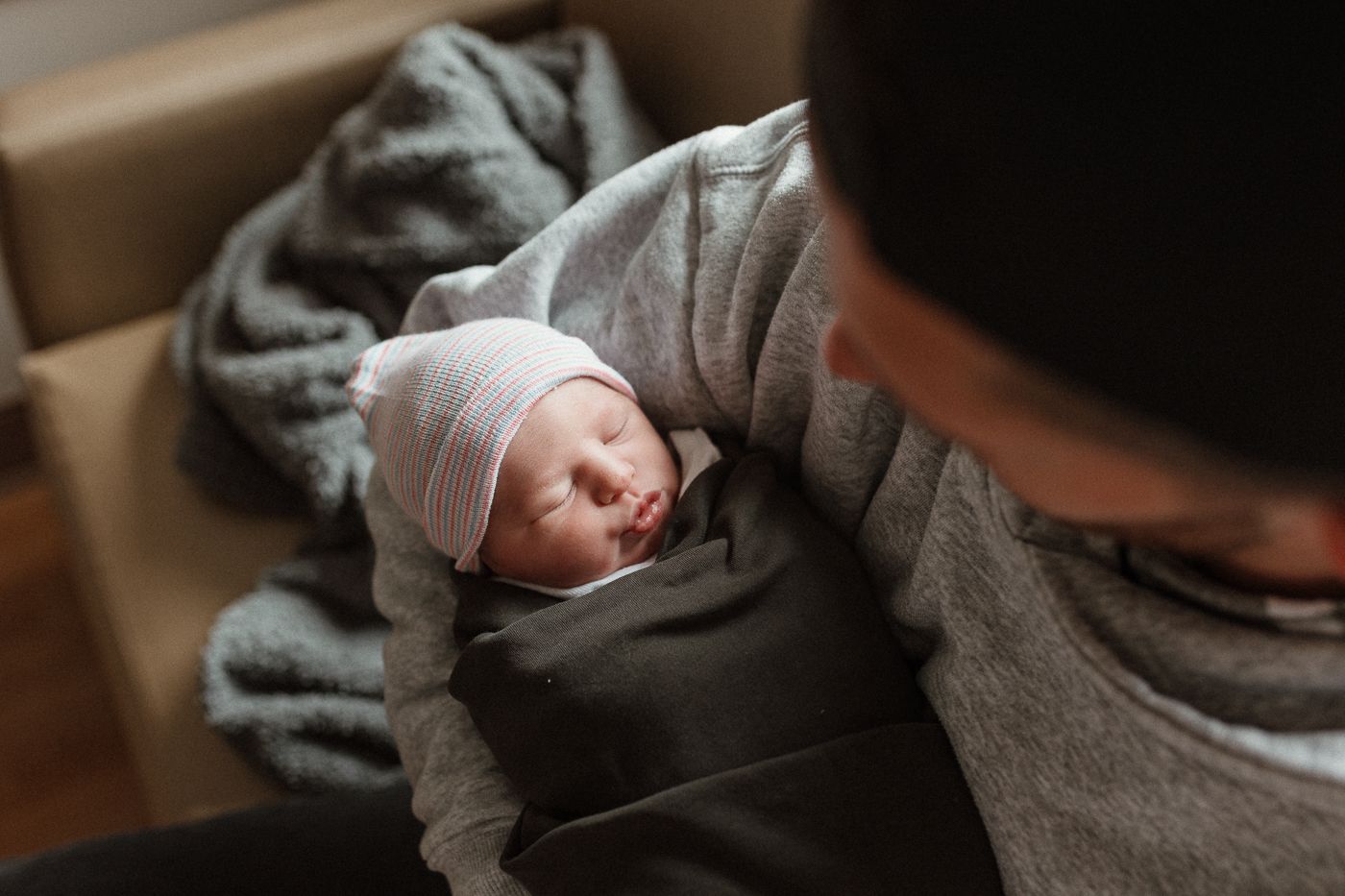 Quiet moment during a fresh 48 between parent + newborn, wrapped in warmth + love, simple, tender, + full of connection using natural light