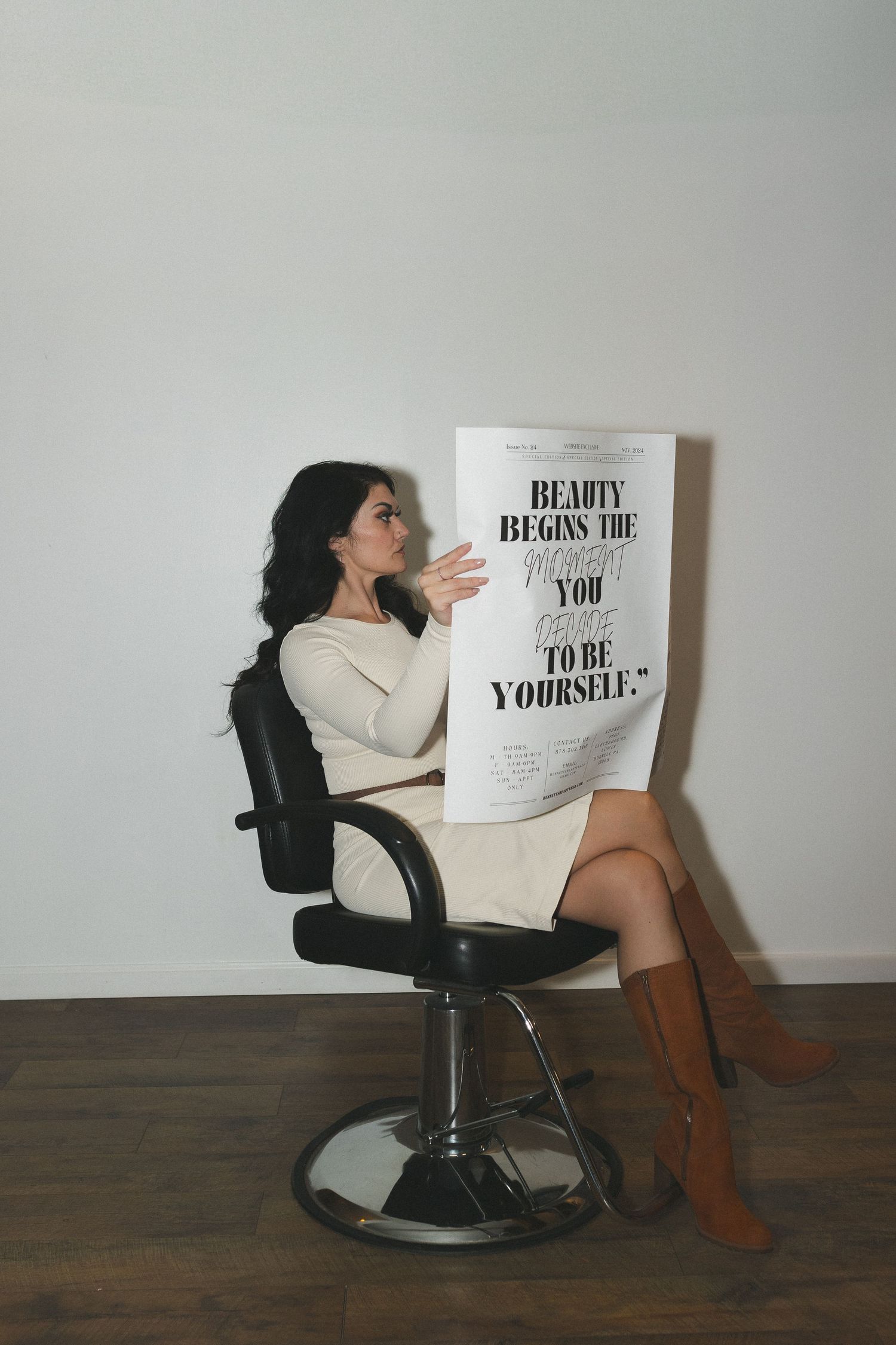 Woman in salon chair reading beauty magazine featuring inspirational text.