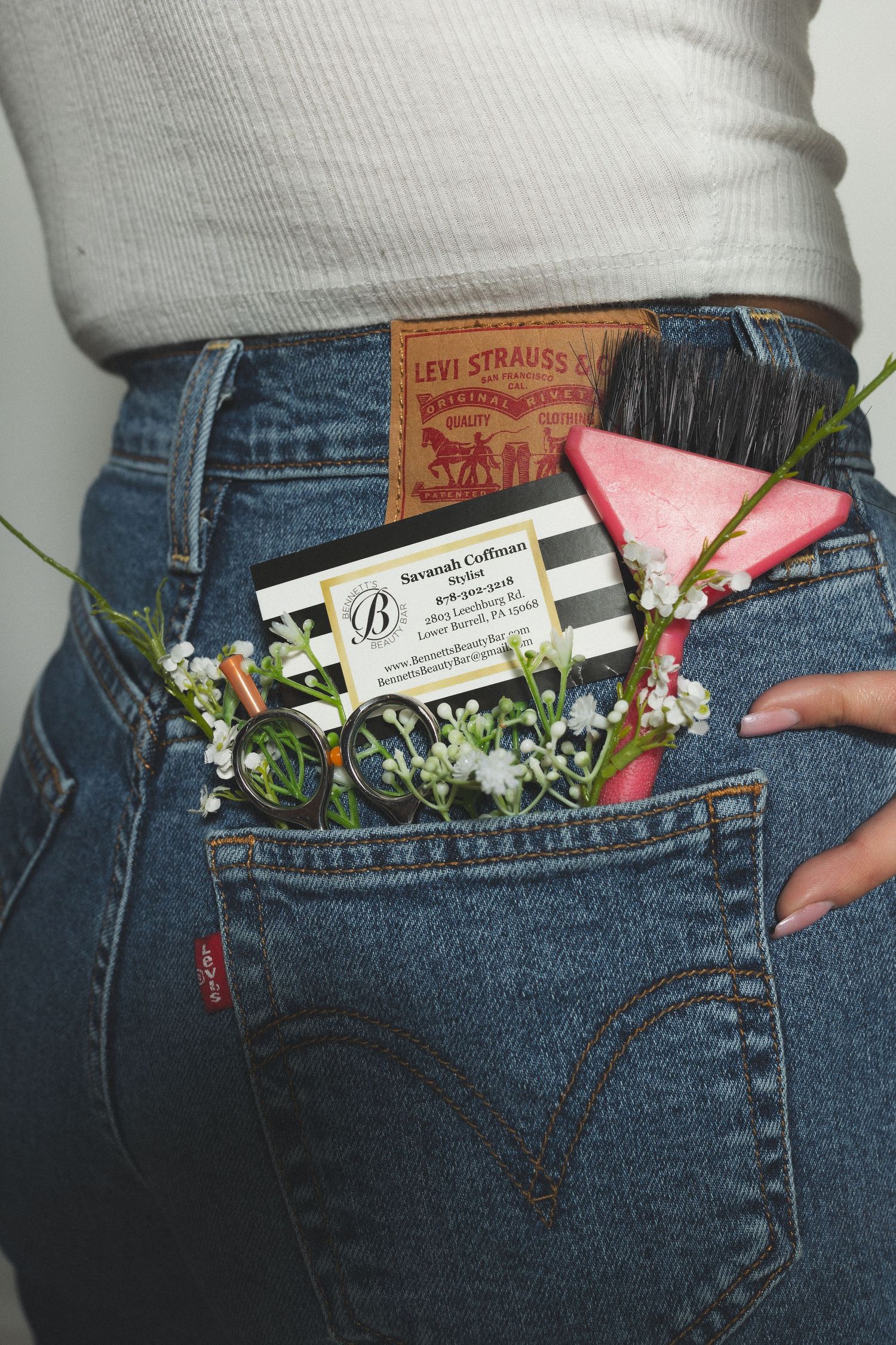 Close up of Levi's jeans pocket with business card and pink flowers tucked inside.