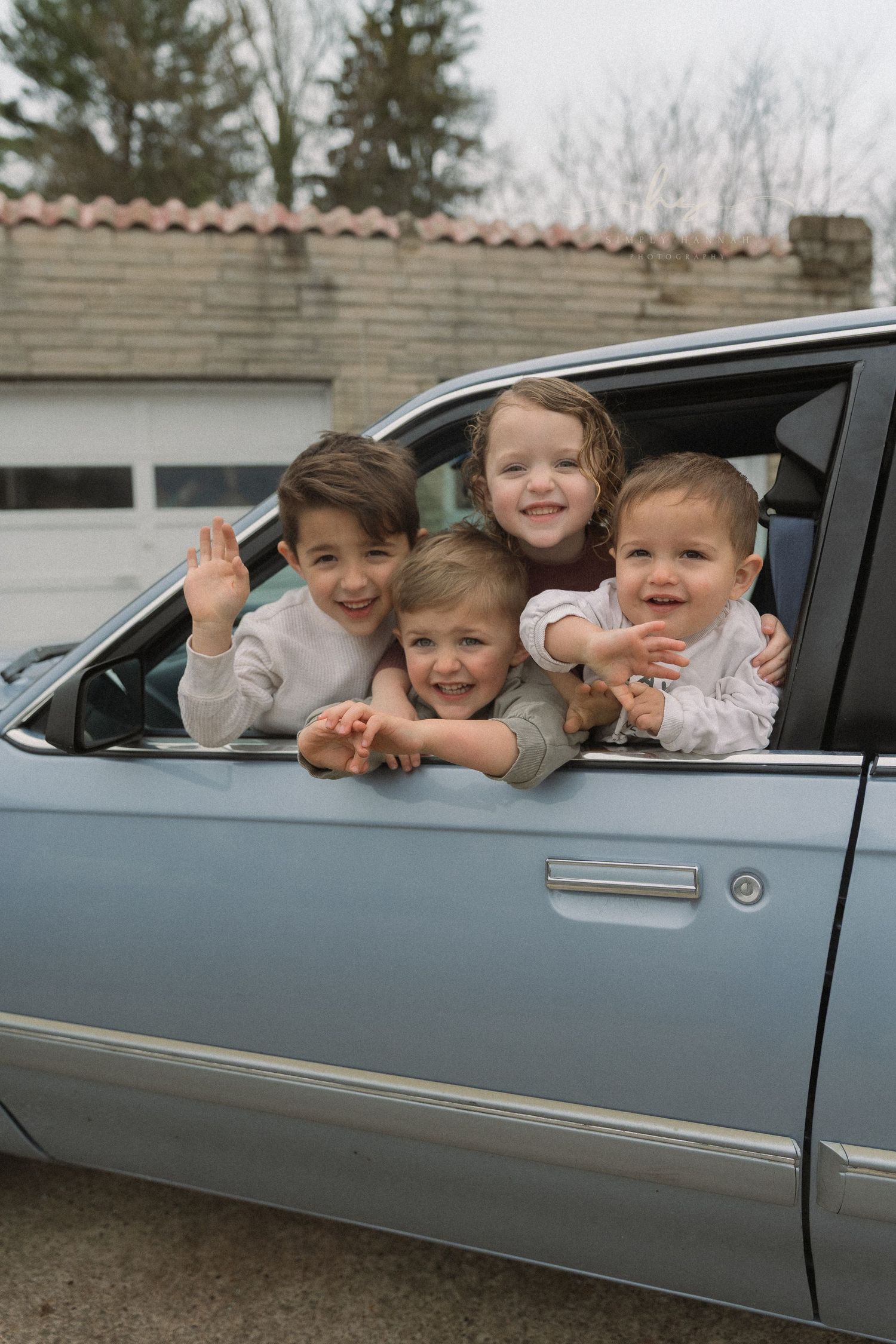 Siblings out of a vintage car window, playful family photography capturing childhood joy + connection with film like, storytelling editing