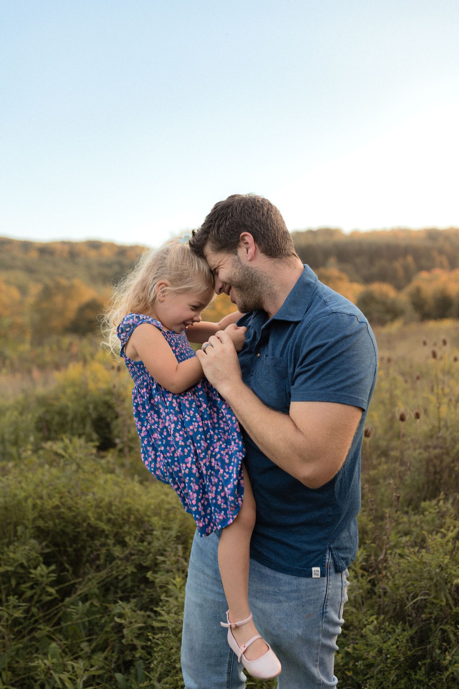 Sweet moment between parent and child during outdoor sunset photo session.