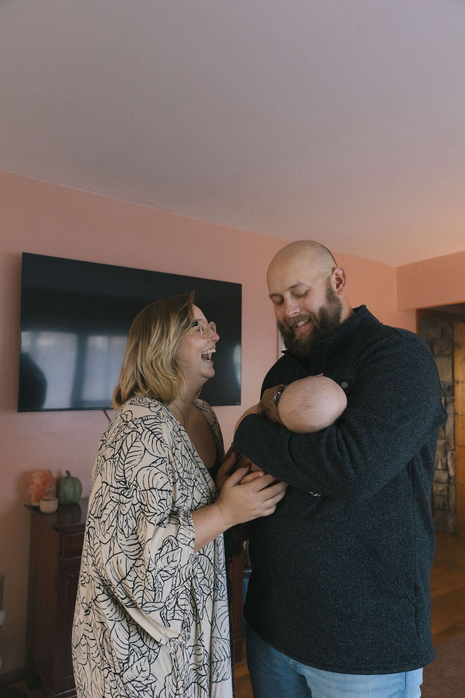 A candid moment of laughter and joy between a couple sharing an intimate moment in their living room.
