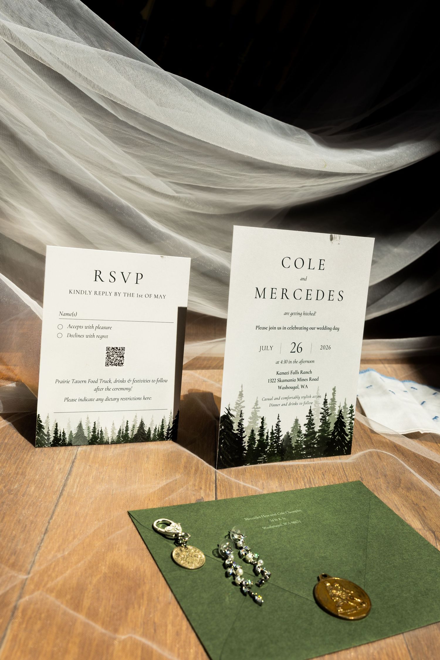 Elegant wedding invitation suite for Cole and Mercedes, July 26, with RSVP card, greenery, and forest tree design on wood.
