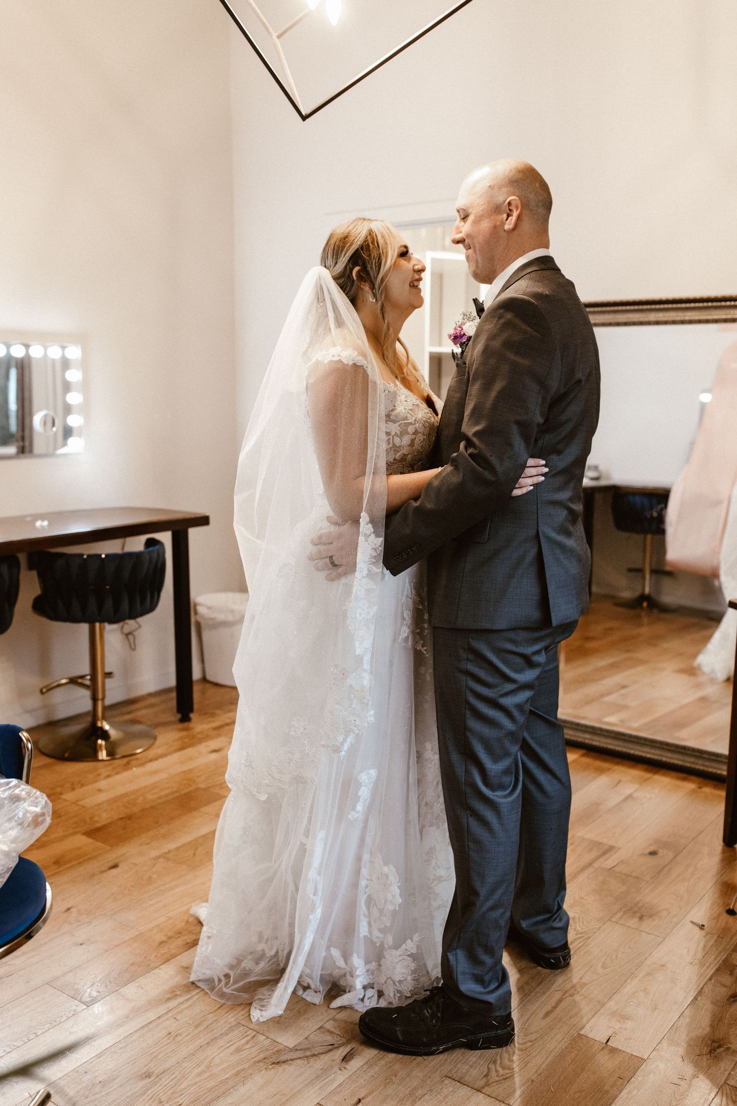Bride and groom share a joyful first look moment indoors.