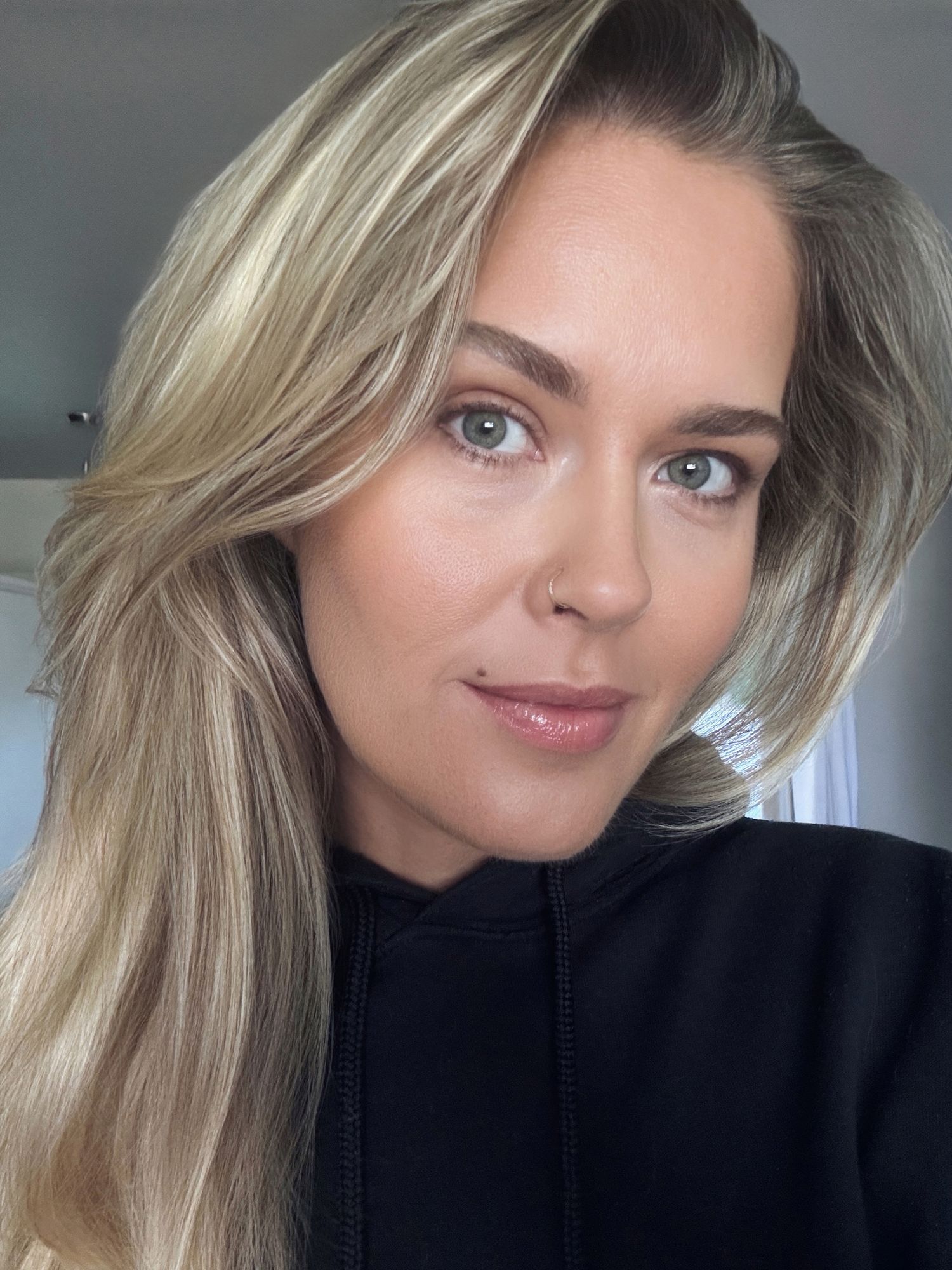 A series of selfie portraits showing blonde hair and natural makeup against a dark background.