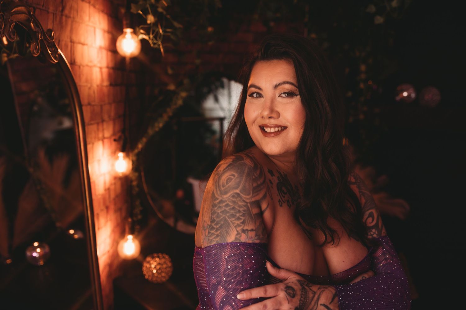 Tattooed woman during boudoir session. Empowerment sessions made to bring the fire back to your soul. Georgetown, SC boudoir studio