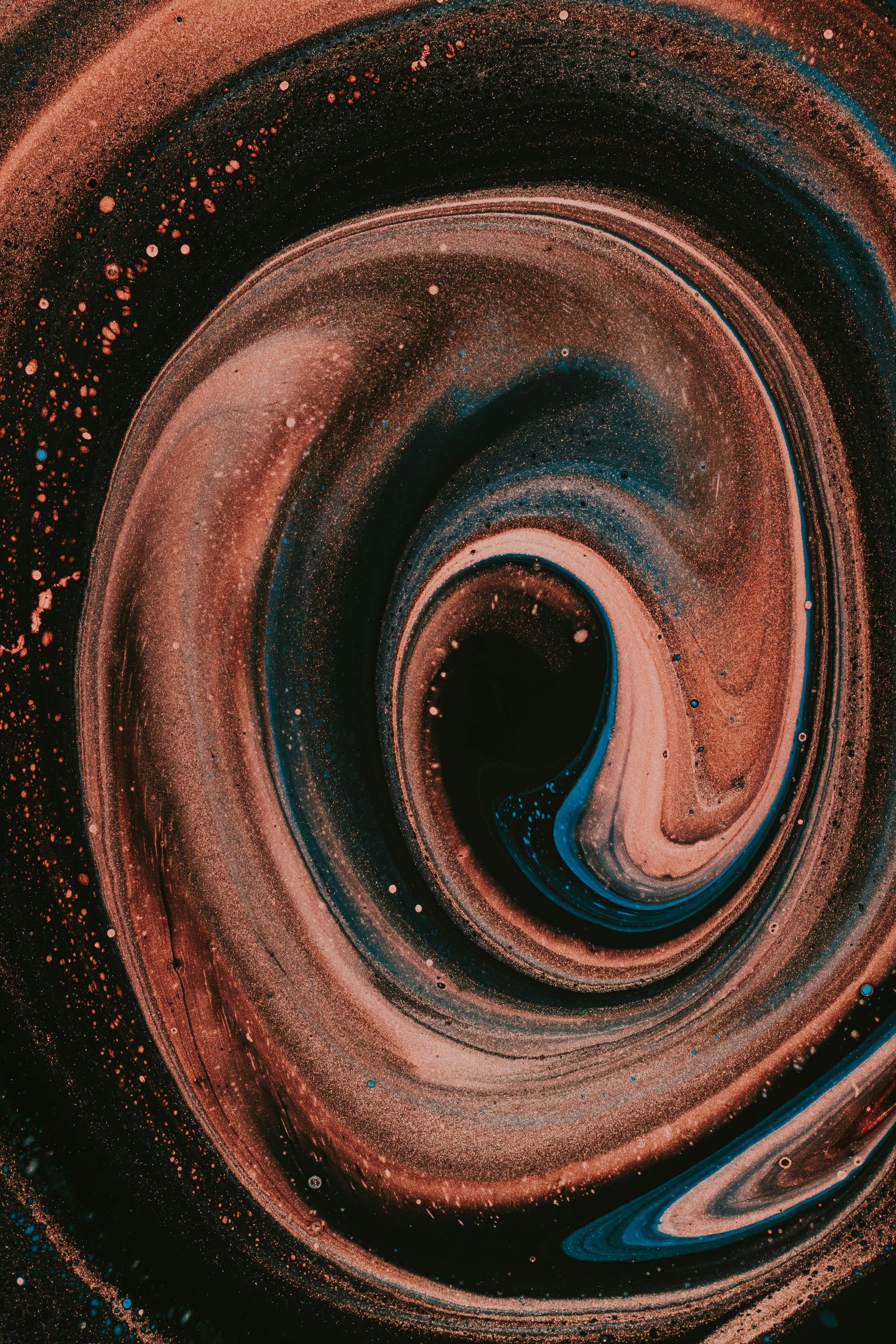 Abstract swirling pattern in brown and blue tones creating a spiral vortex effect with speckled texture throughout.