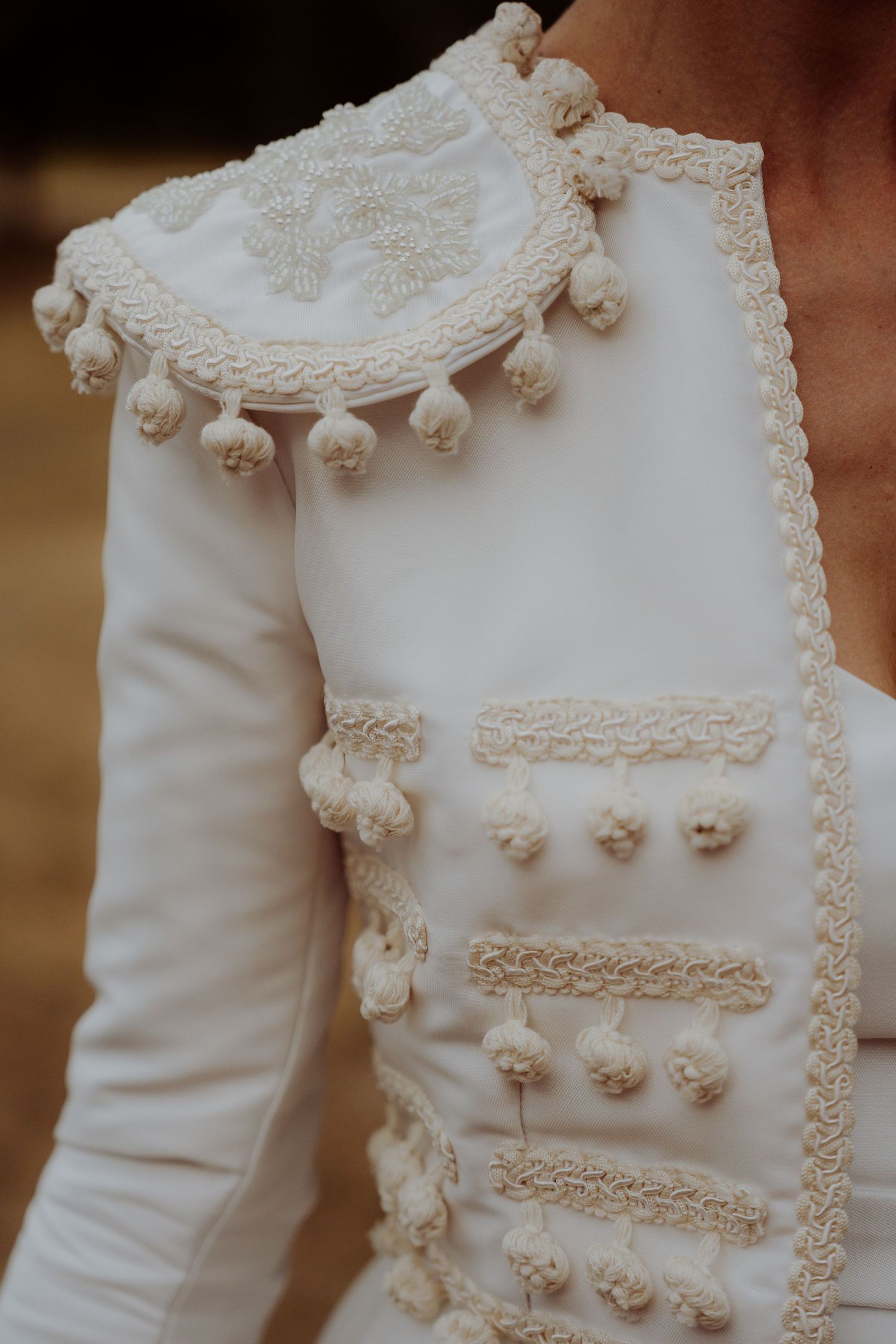 Gros plan sur les détails d'une robe de mariée blanche ornée de dentelle délicate et de pompons décoratifs. Photographie éditoriale