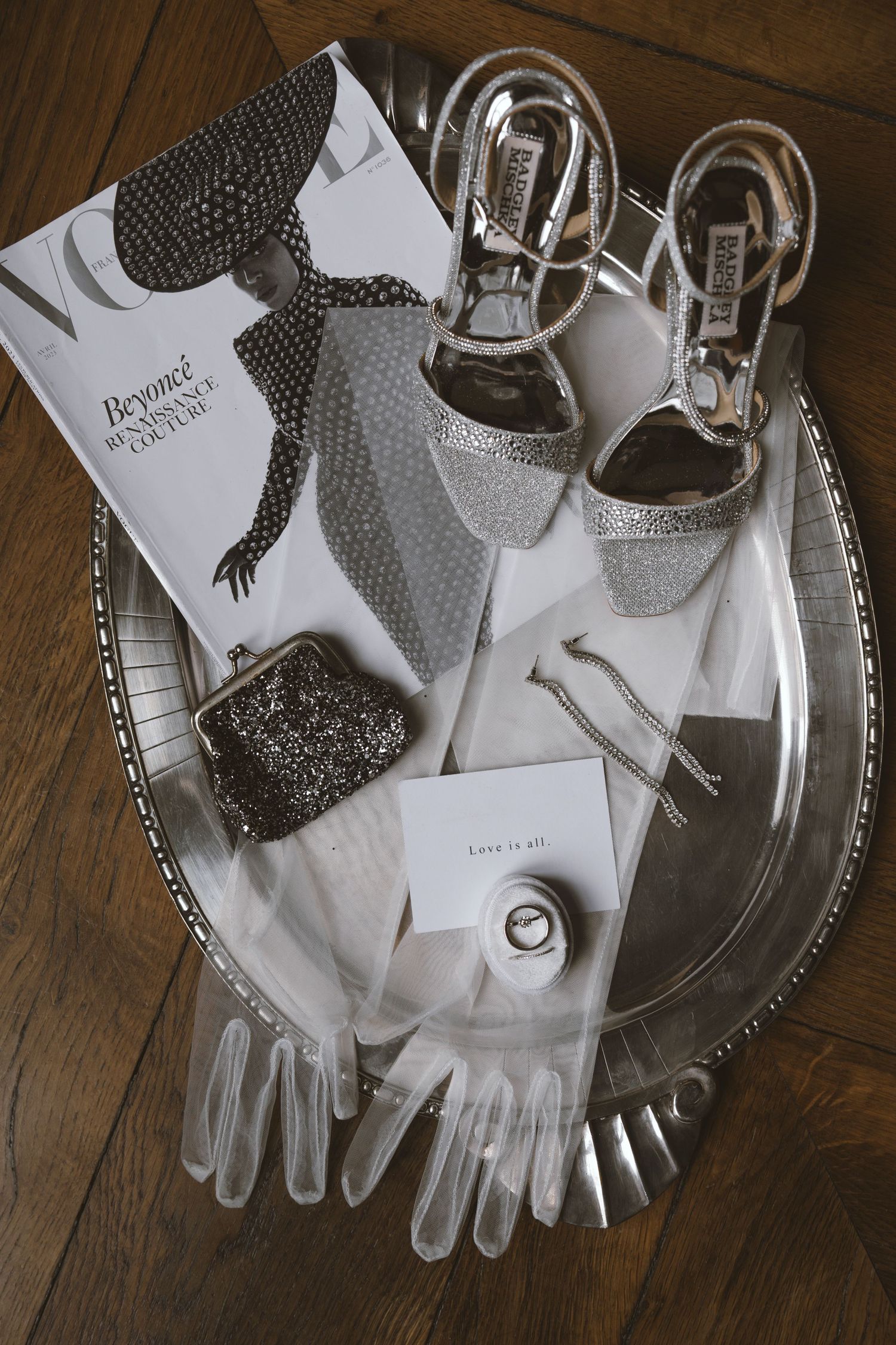Silver bridal accessories on tray with Vogue Beyonce magazine, crystal heels, gloves, ring, and glitter clutch.