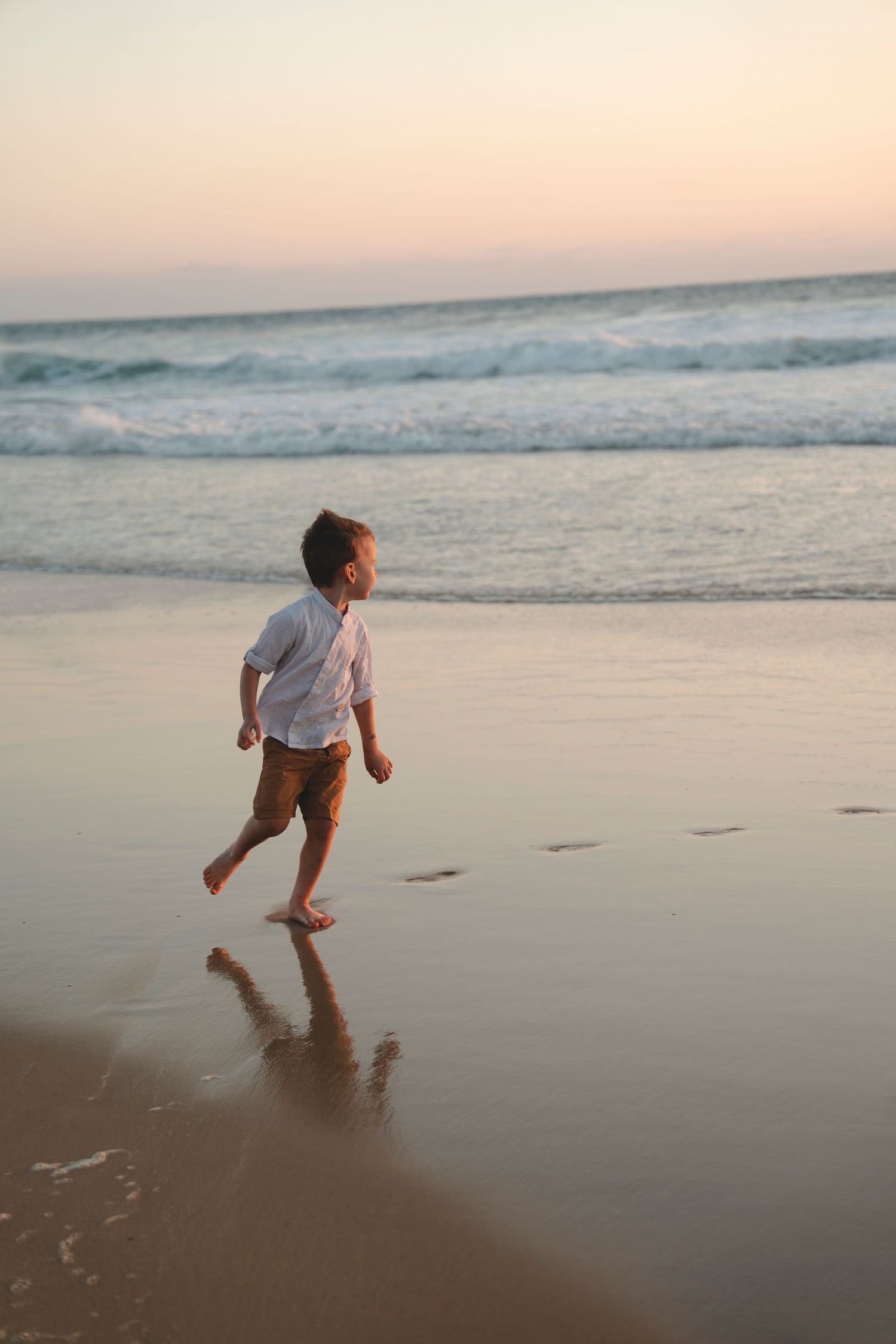 Portrait enfant séance lifestyle sur la plage au coucher de soleil.