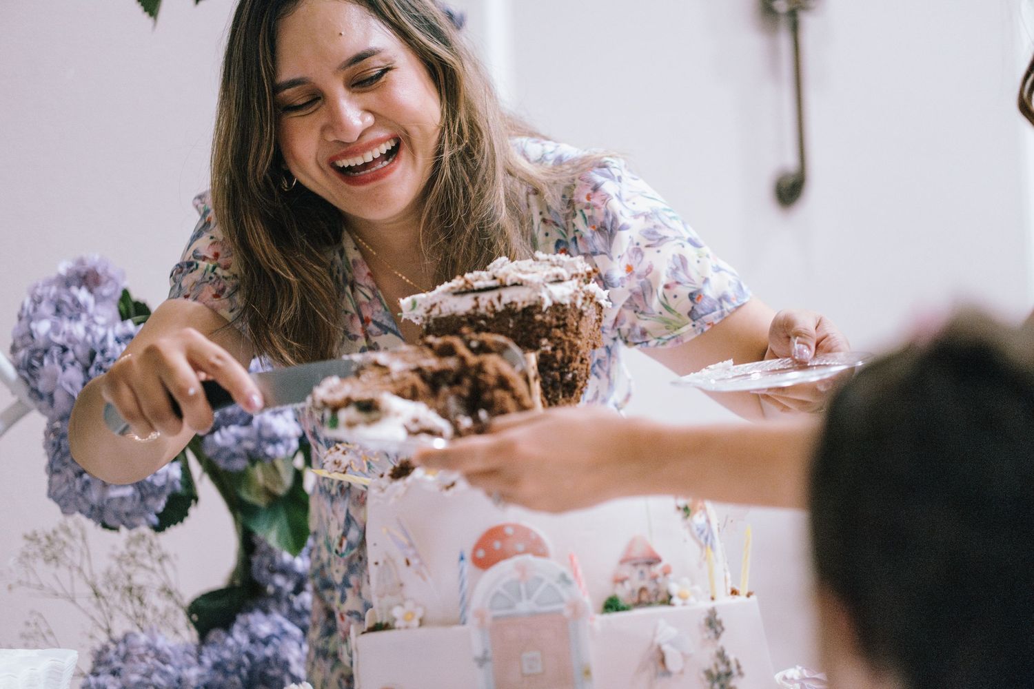 Joyful laughter around a table during a celebration with floral decor.