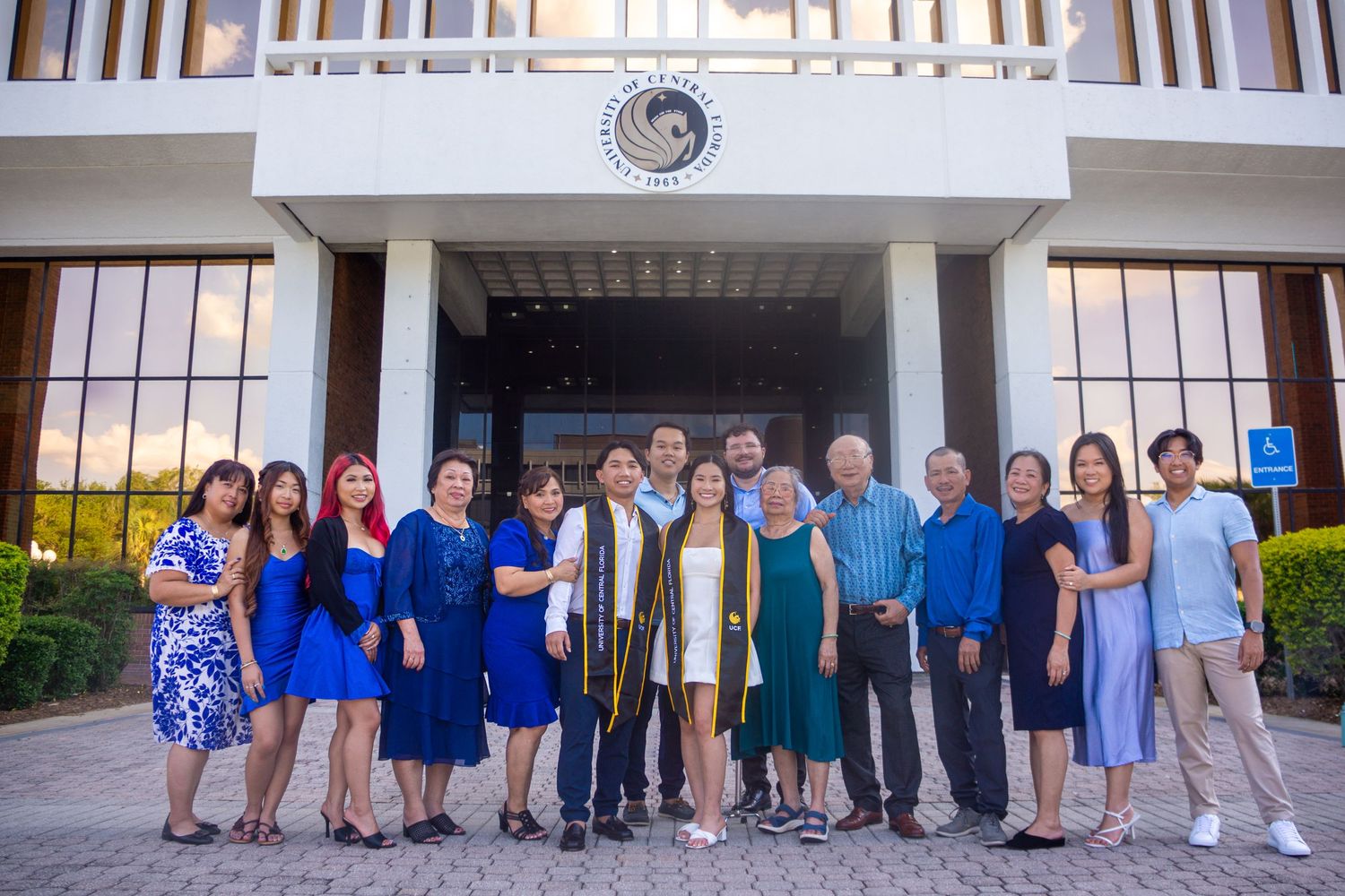 Group photo of graduates and family members standing in front of university entrance.