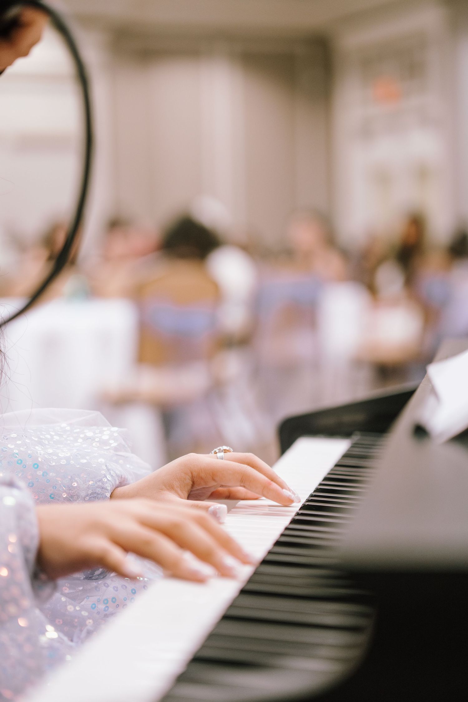 Close-up of hands playing piano keys during a formal event.