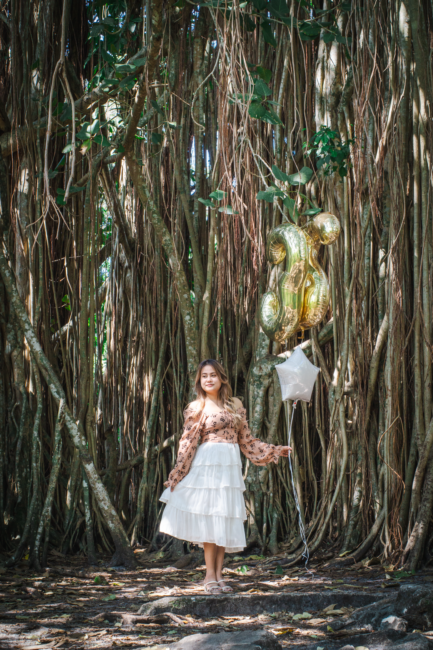 A magical forest scene with hanging vines and gold balloon decorations.