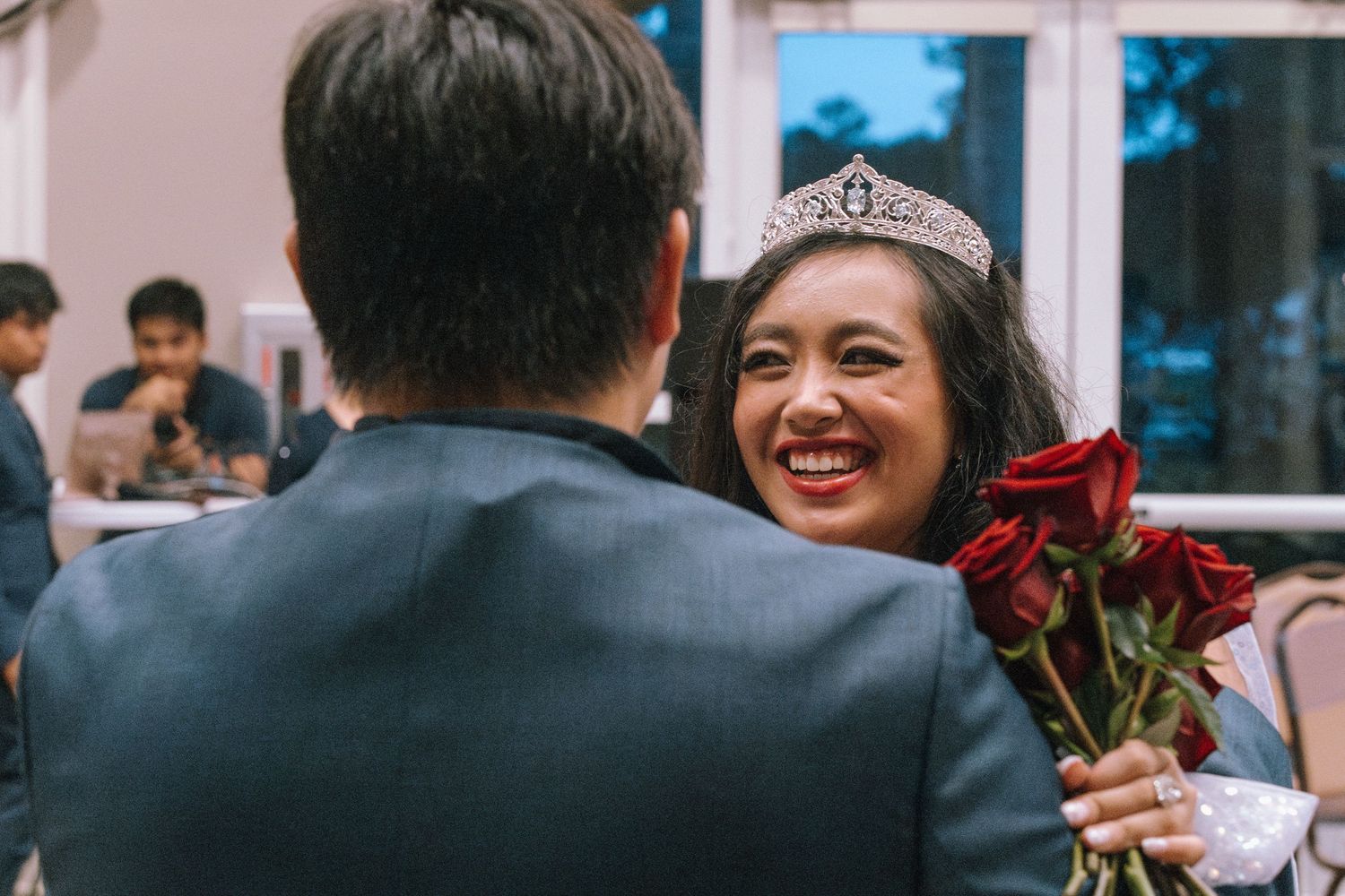 A joyful celebratory moment with roses and a tiara.