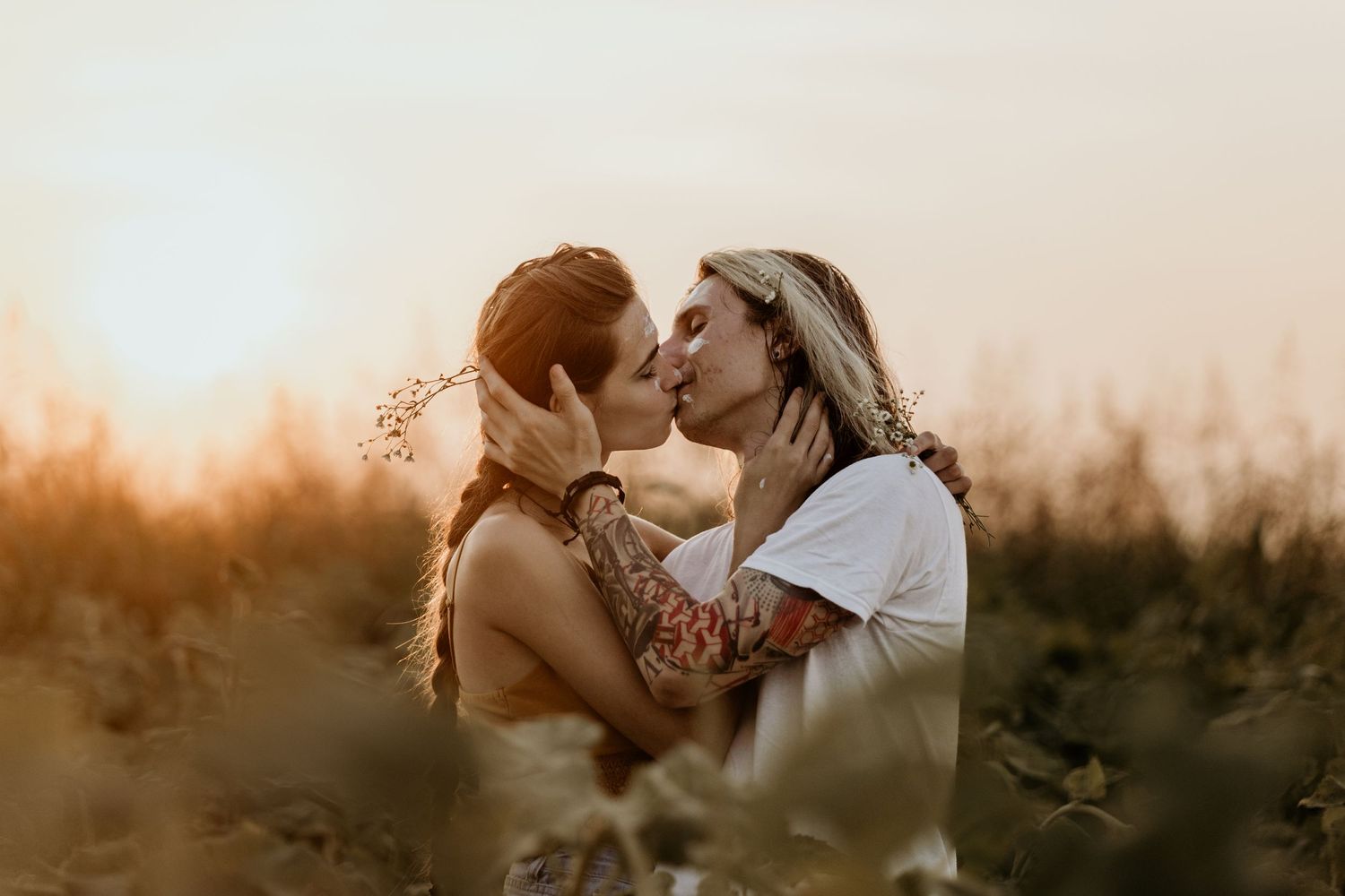 Romantic couple sharing an intimate moment while surrounded by nature at golden hour.