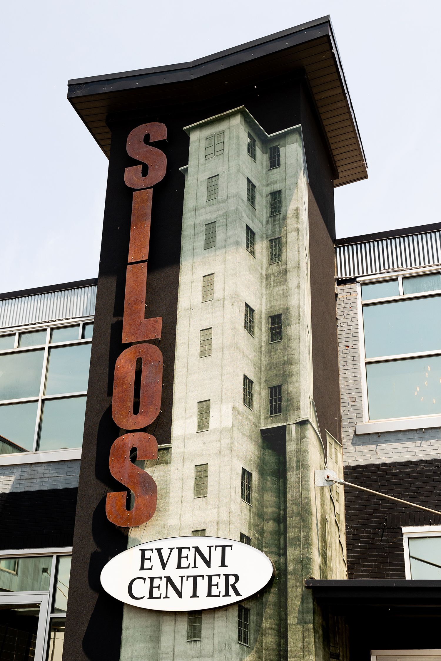 Tall modern event center building with large vertical 'SILOS' signage and oval 'EVENT CENTER' sign mounted on exterior wall.