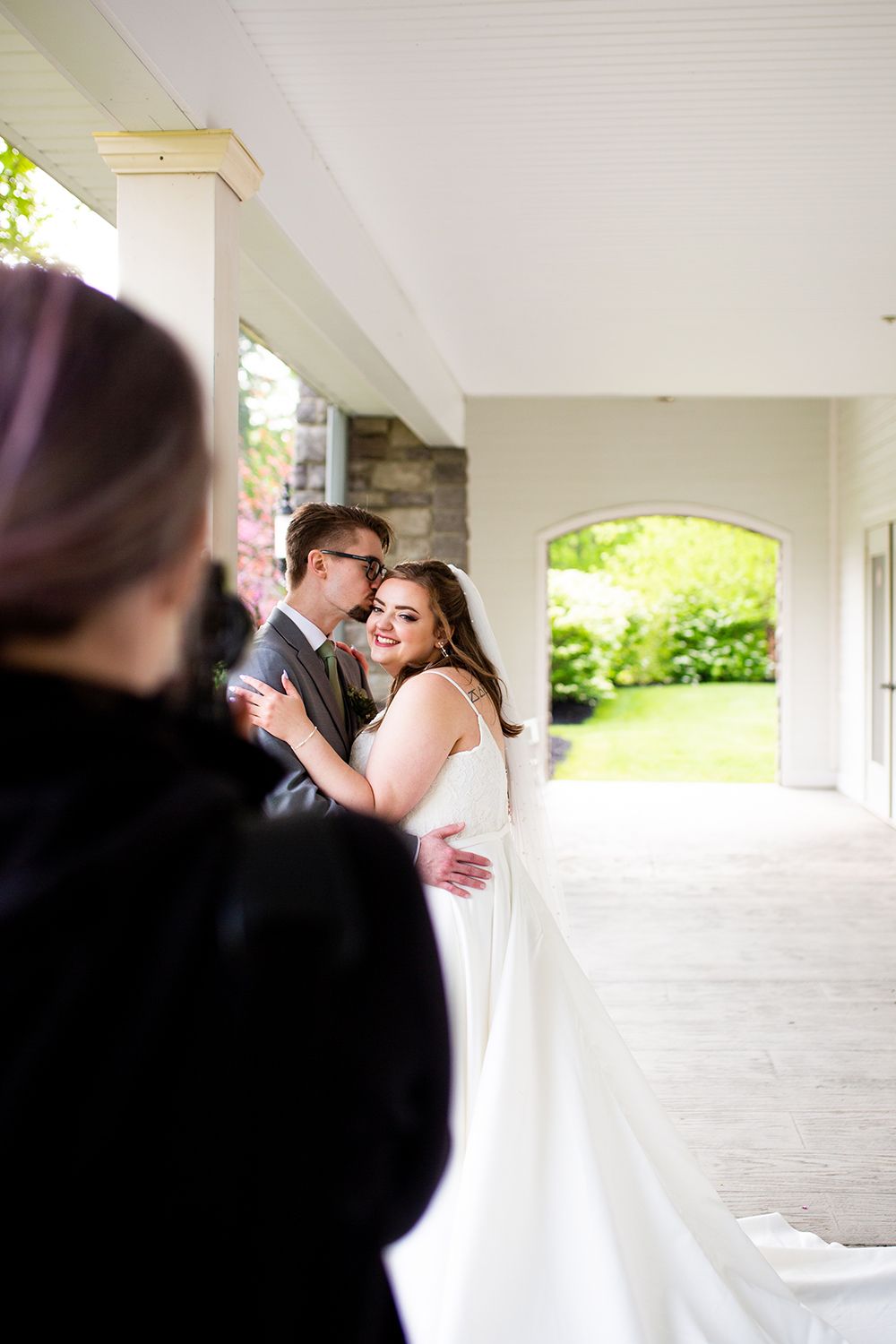 A romantic wedding photoshoot sequence showing silhouettes of a couple embracing under a covered outdoor walkway.