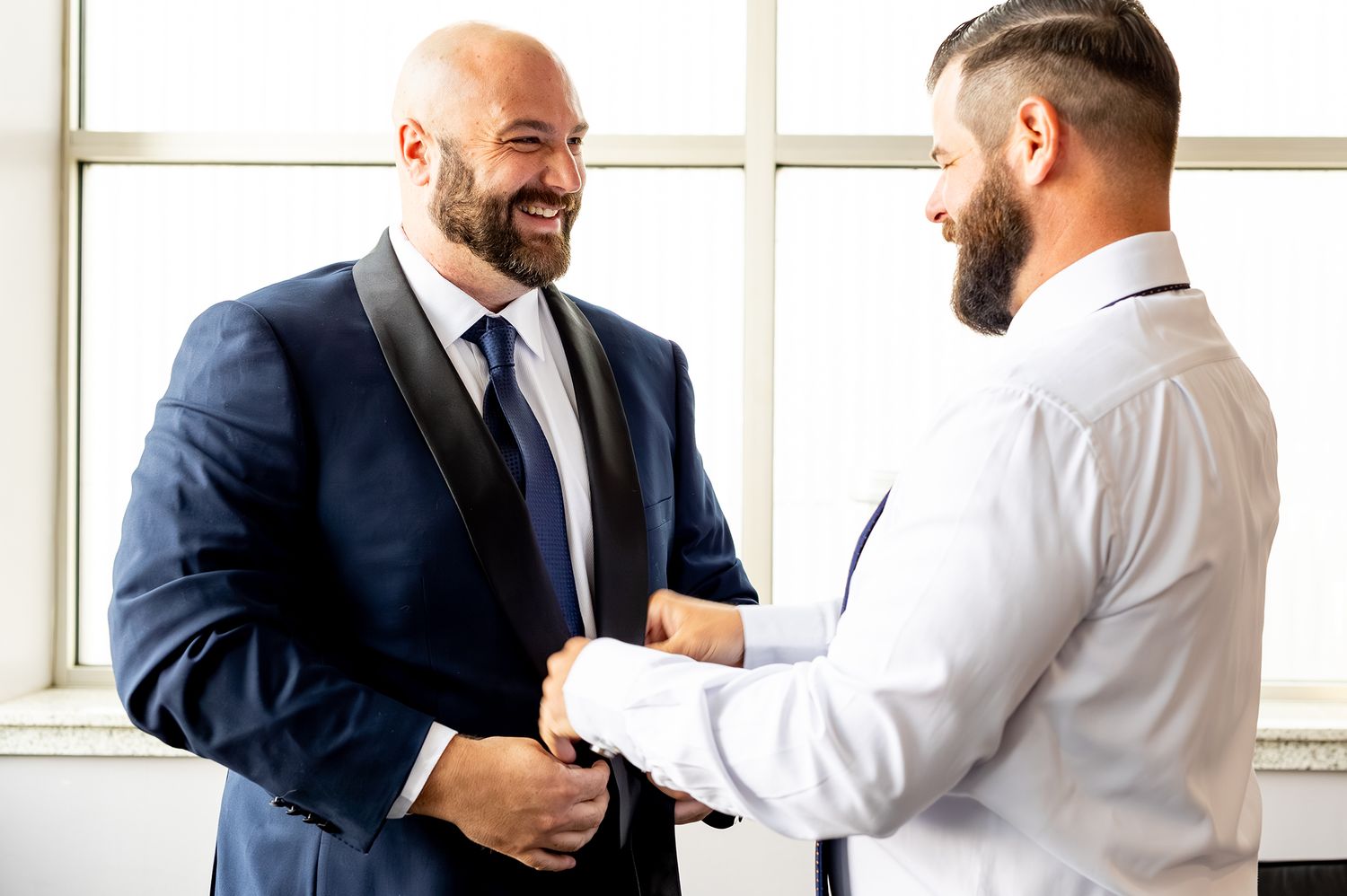 Business professionals in suits shake hands during a meeting in a bright modern office space.