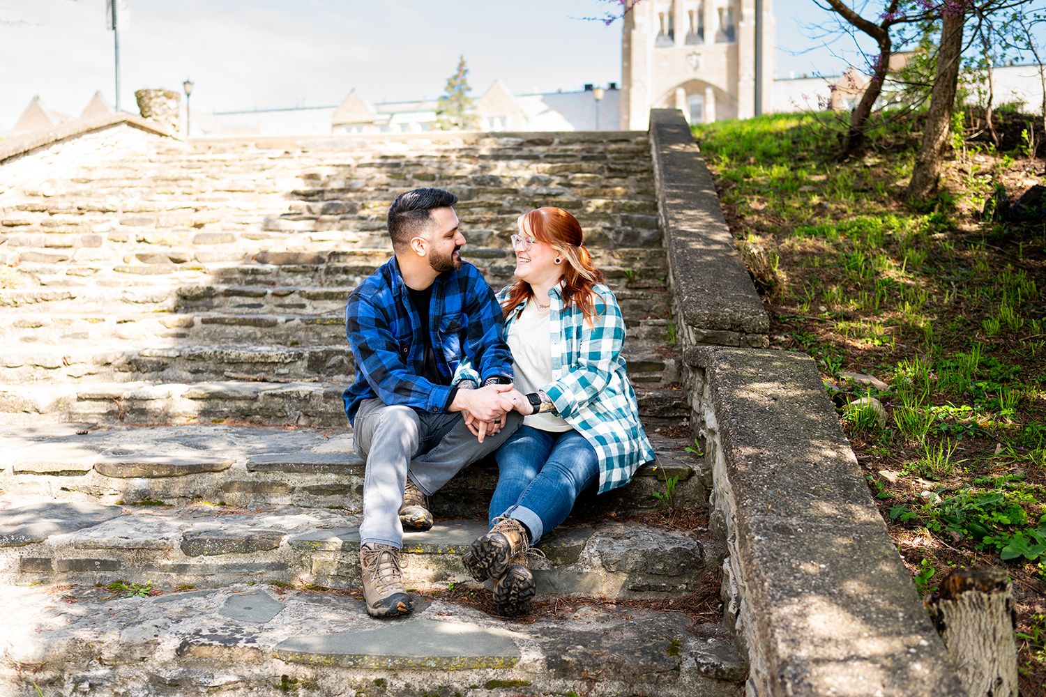 A couple sits together on stone steps while enjoying a quiet conversation outdoors.