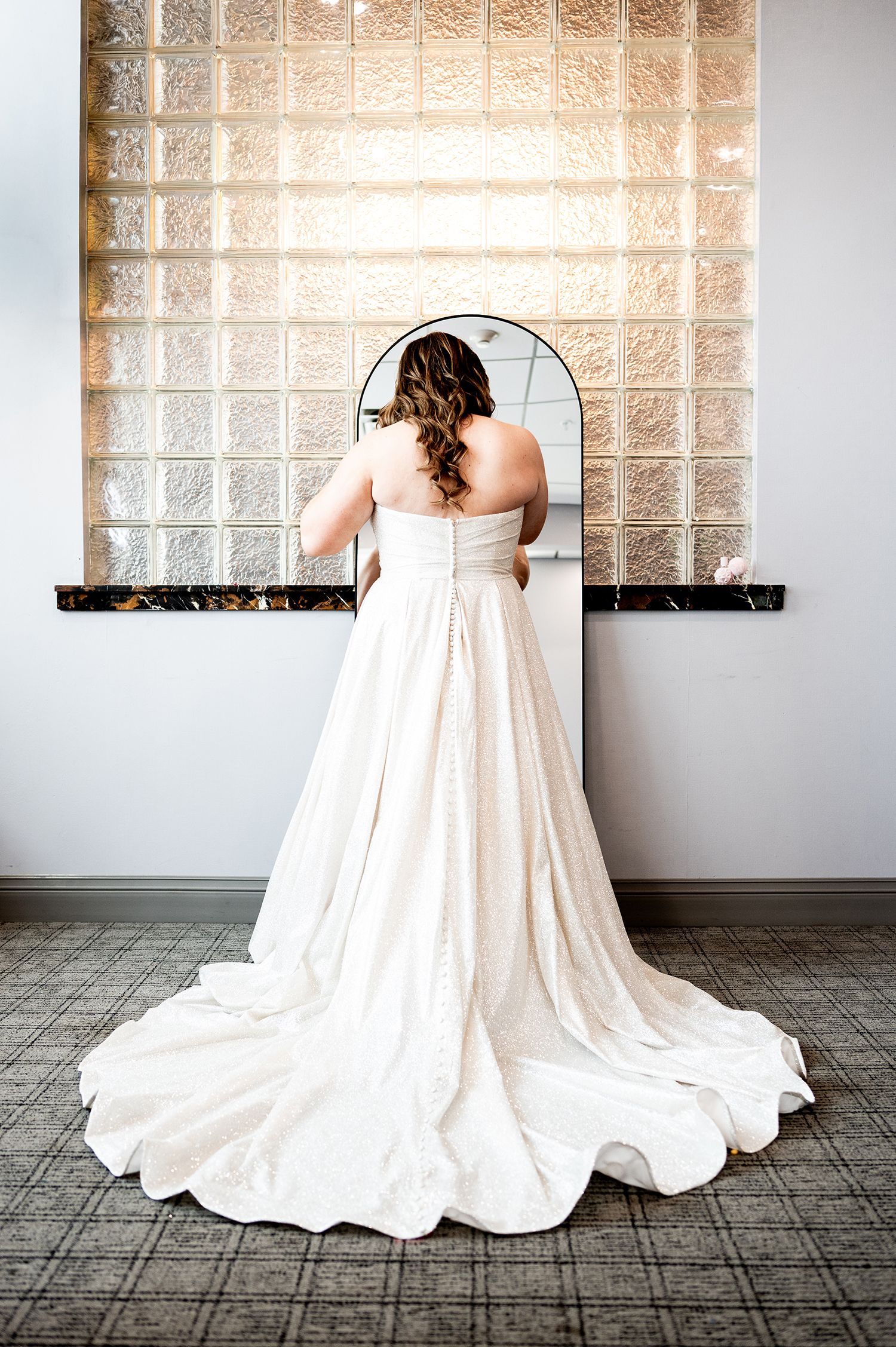 A series of wedding dress photos showing the flowing white train elegantly arranged on textured floor tiles.
