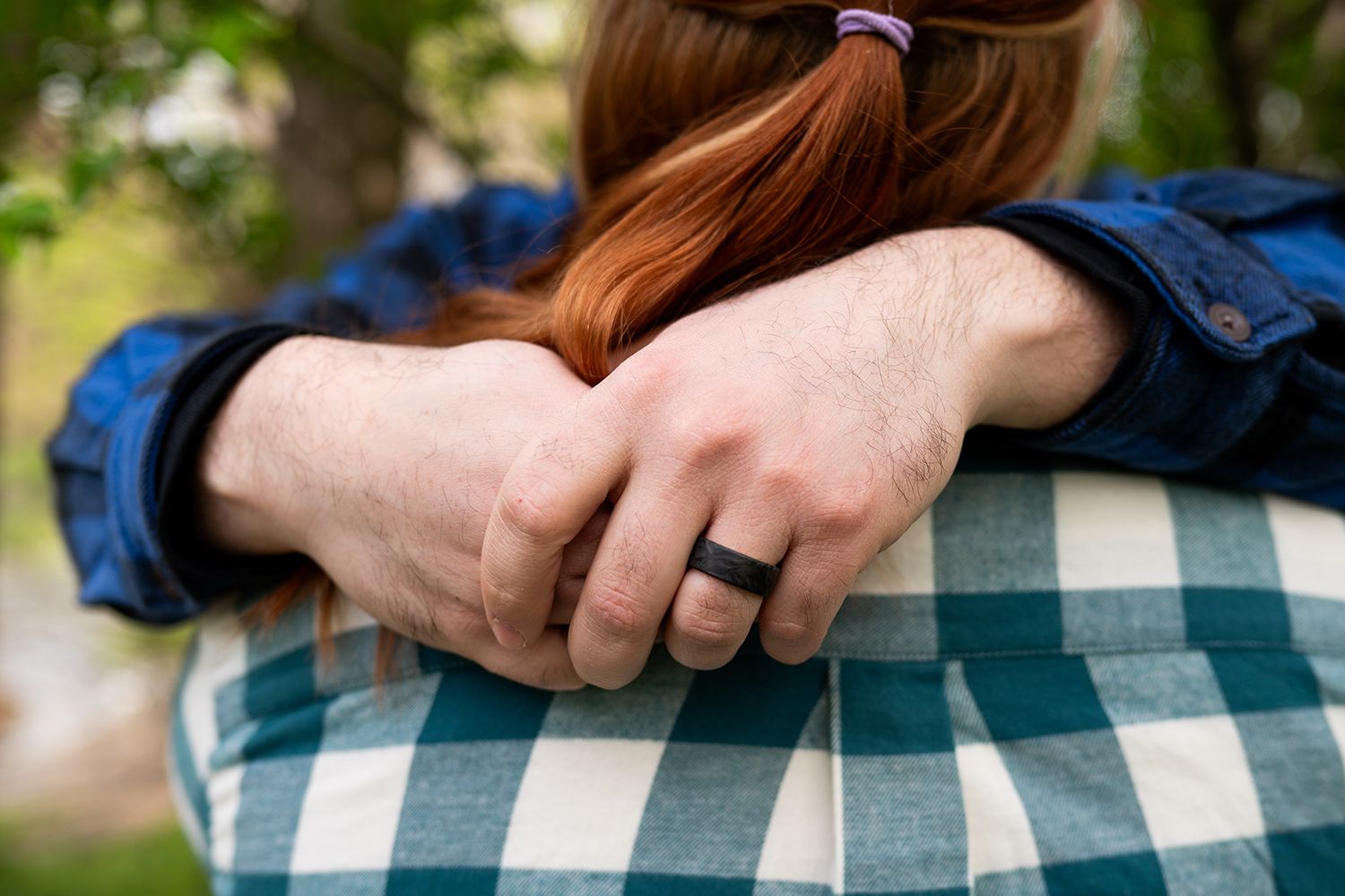 A series of step-by-step images showing how to fold a white and blue plaid button-up shirt neatly.