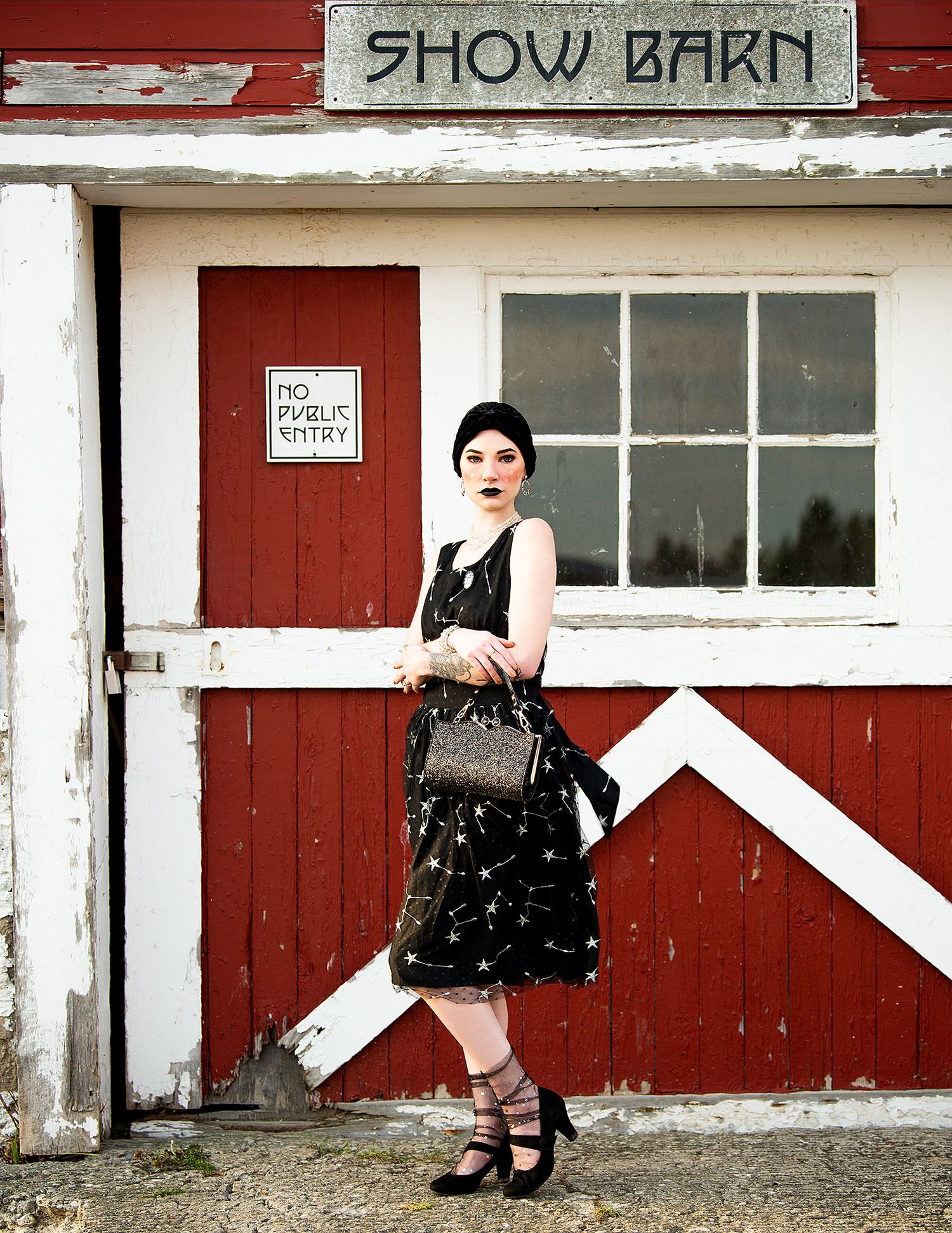 A vintage-inspired fashion photo against a red barn with 