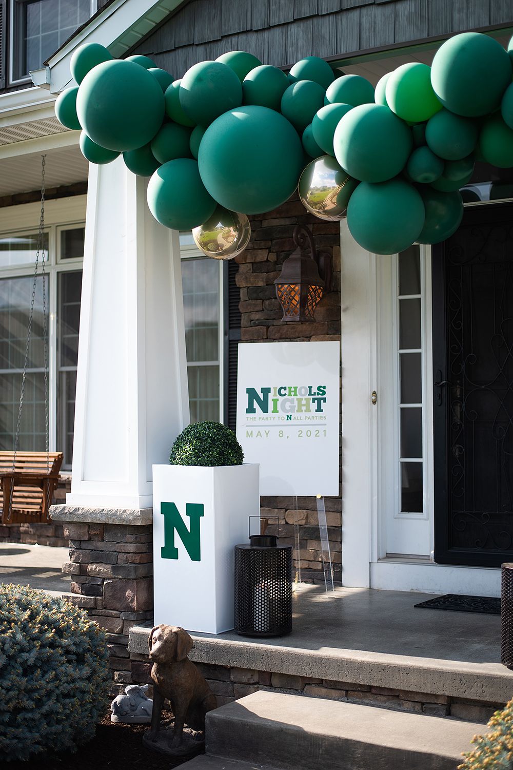 Green balloon decorations adorn a white storefront entrance with a green 'N' logo sign.