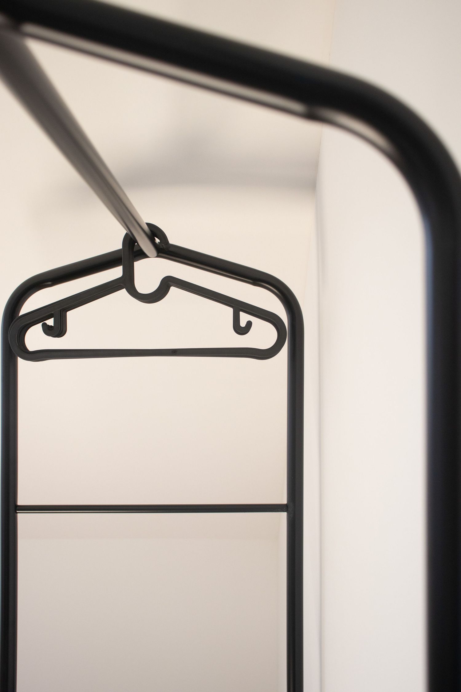 Bild einer Kleiderstange sehr minimalistisch Fotografiert - schwarz - weiß hell und Detail