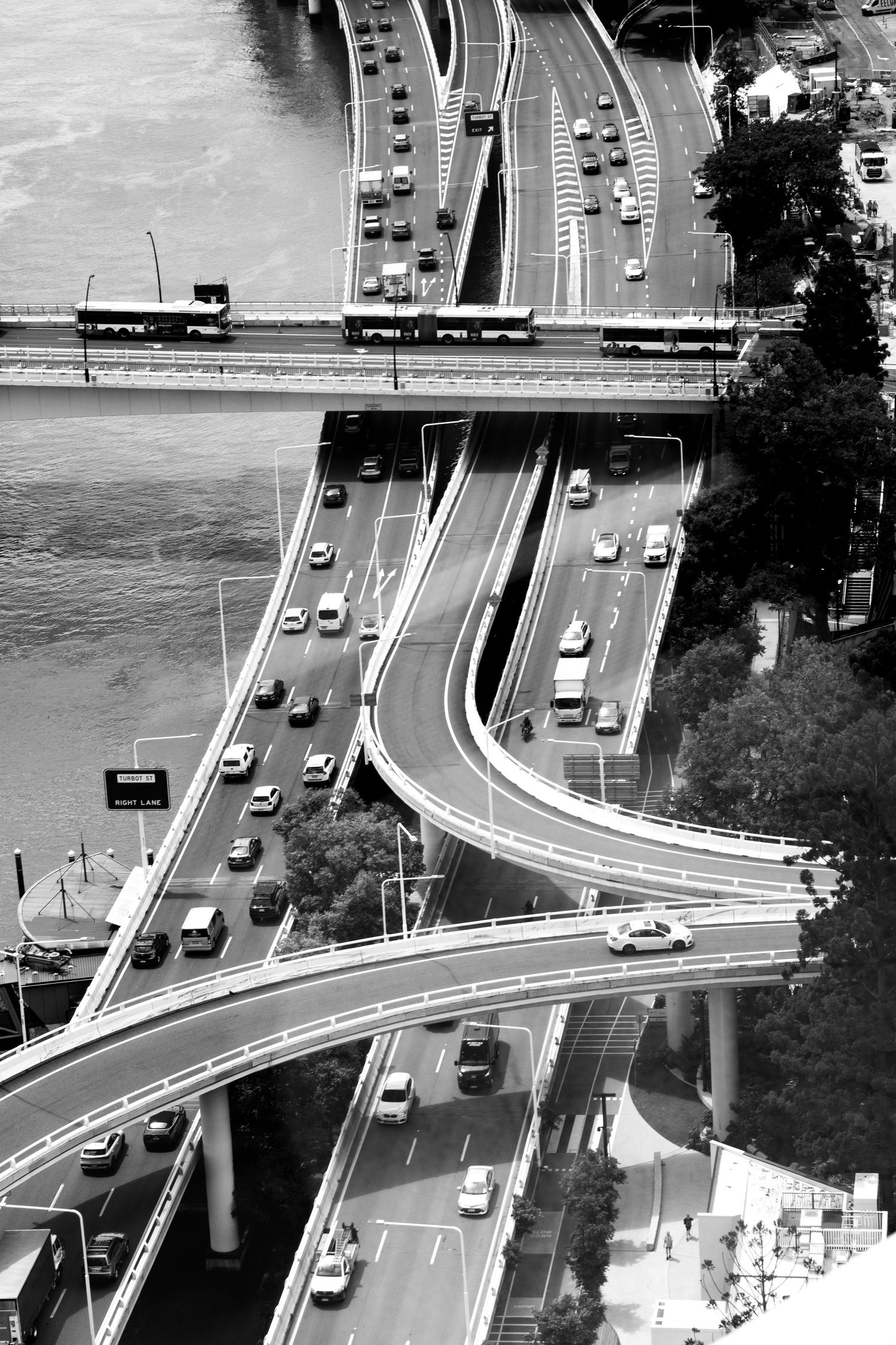 Schwarz/weißaufnahme: Autobahn, die sich unter einem klaren Himmel durch die Landschaft zieht, mit Fahrzeugen