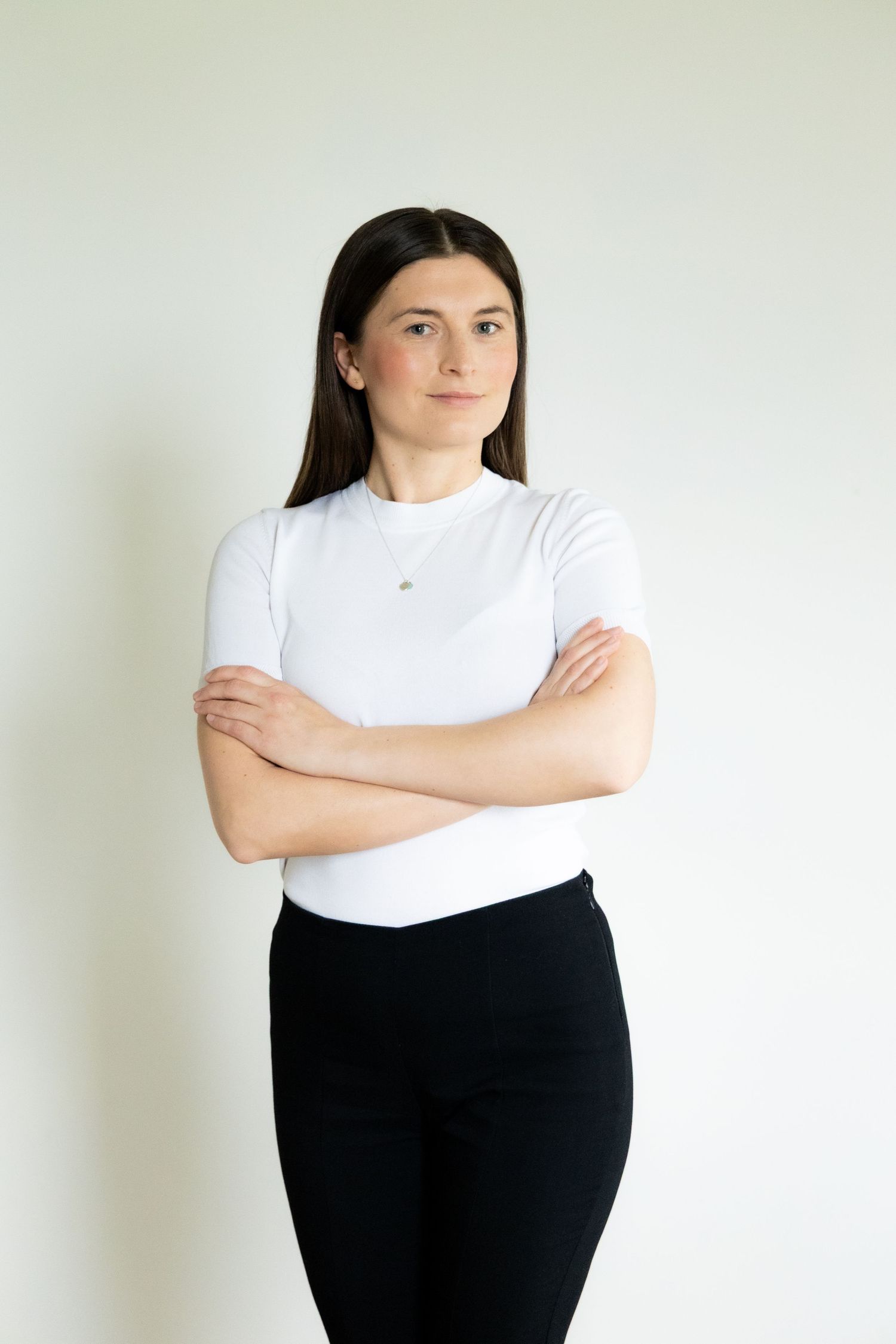 Elegantes Business-Porträt einer Frau in einem modernen Arbeitsumfeld, das ihre Professionalität und Ausstrahlung betont.