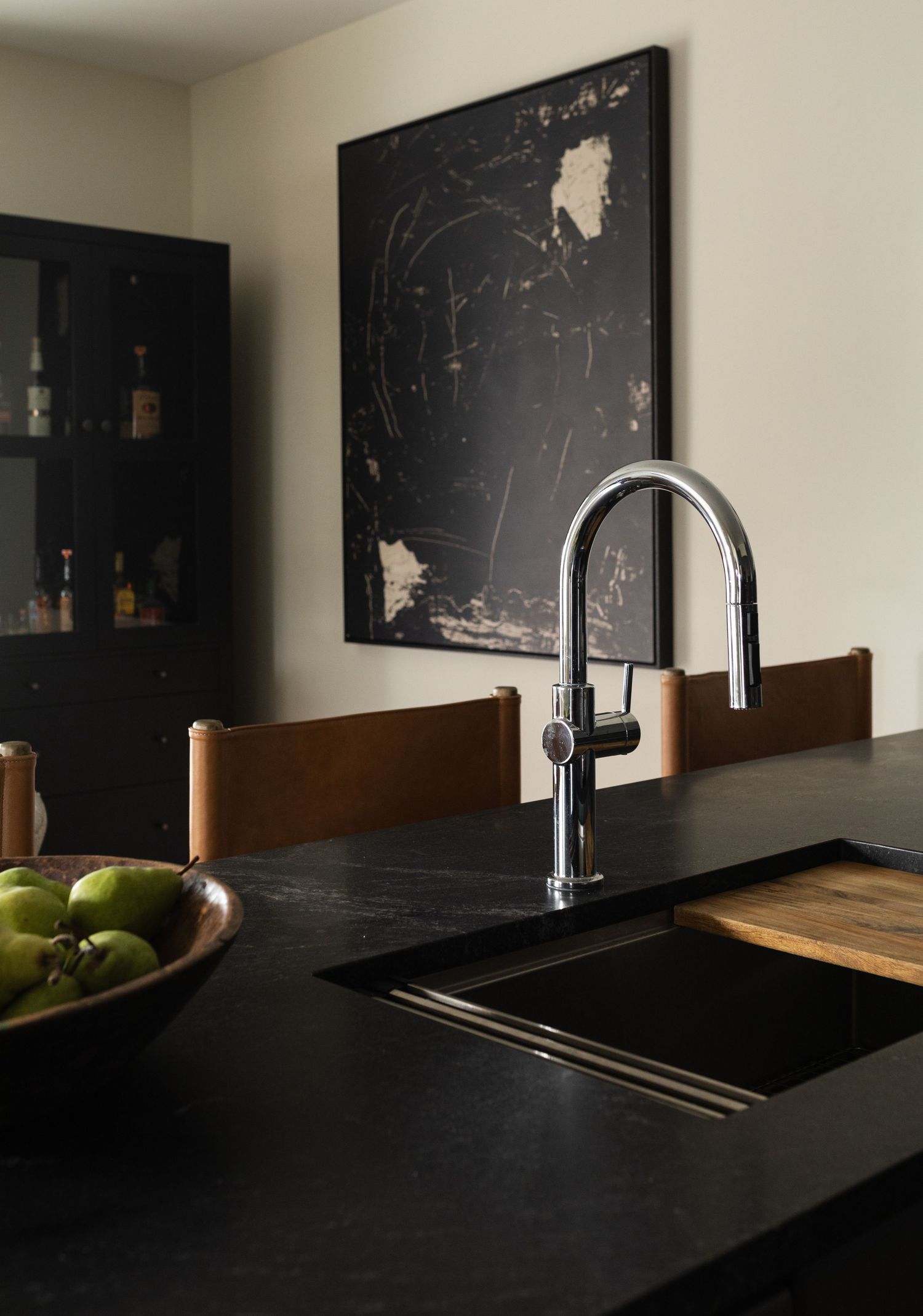 Stylish black kitchen countertop with modern sink and faucet installation in natural lighting.