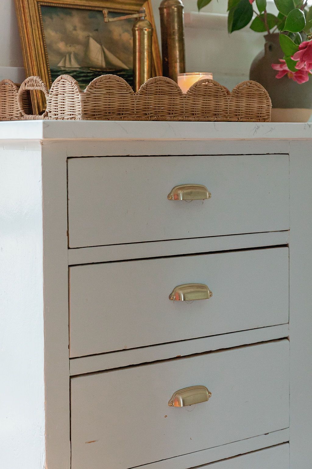 White mid-century modern dresser drawer showing detailed craftsmanship with brass cup pull hardware.