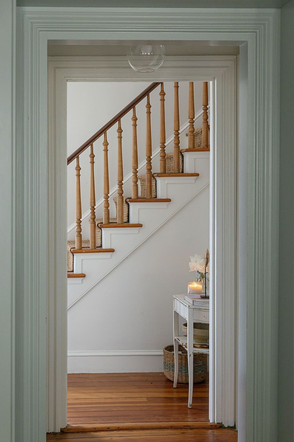 Elegant wooden staircase with white walls and wooden banister in traditional home interior featuring warm hardwood floors.
