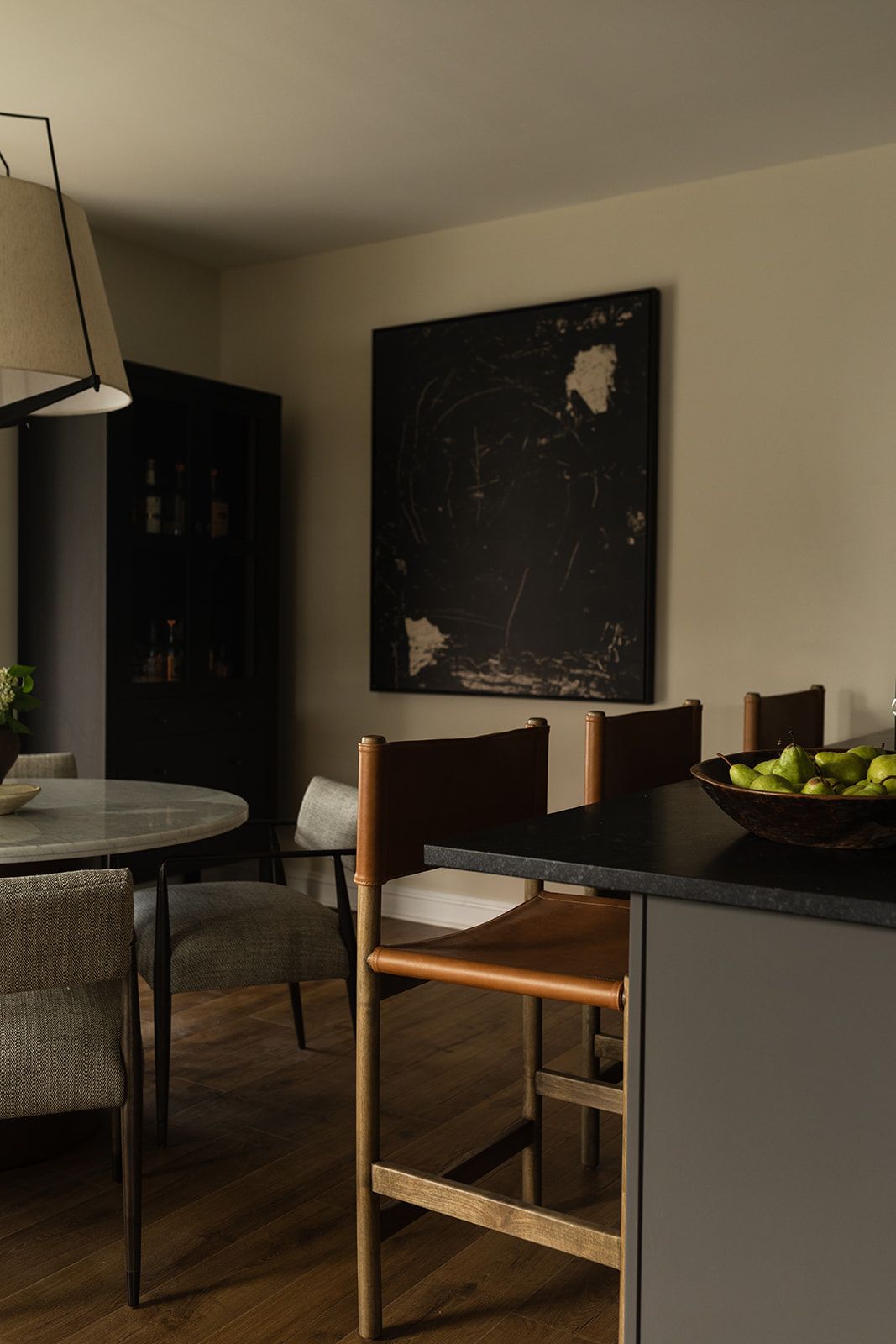 Modern living room corner featuring a dark mounted TV, wooden furniture, and a sleek minimalist design with hardwood flooring.